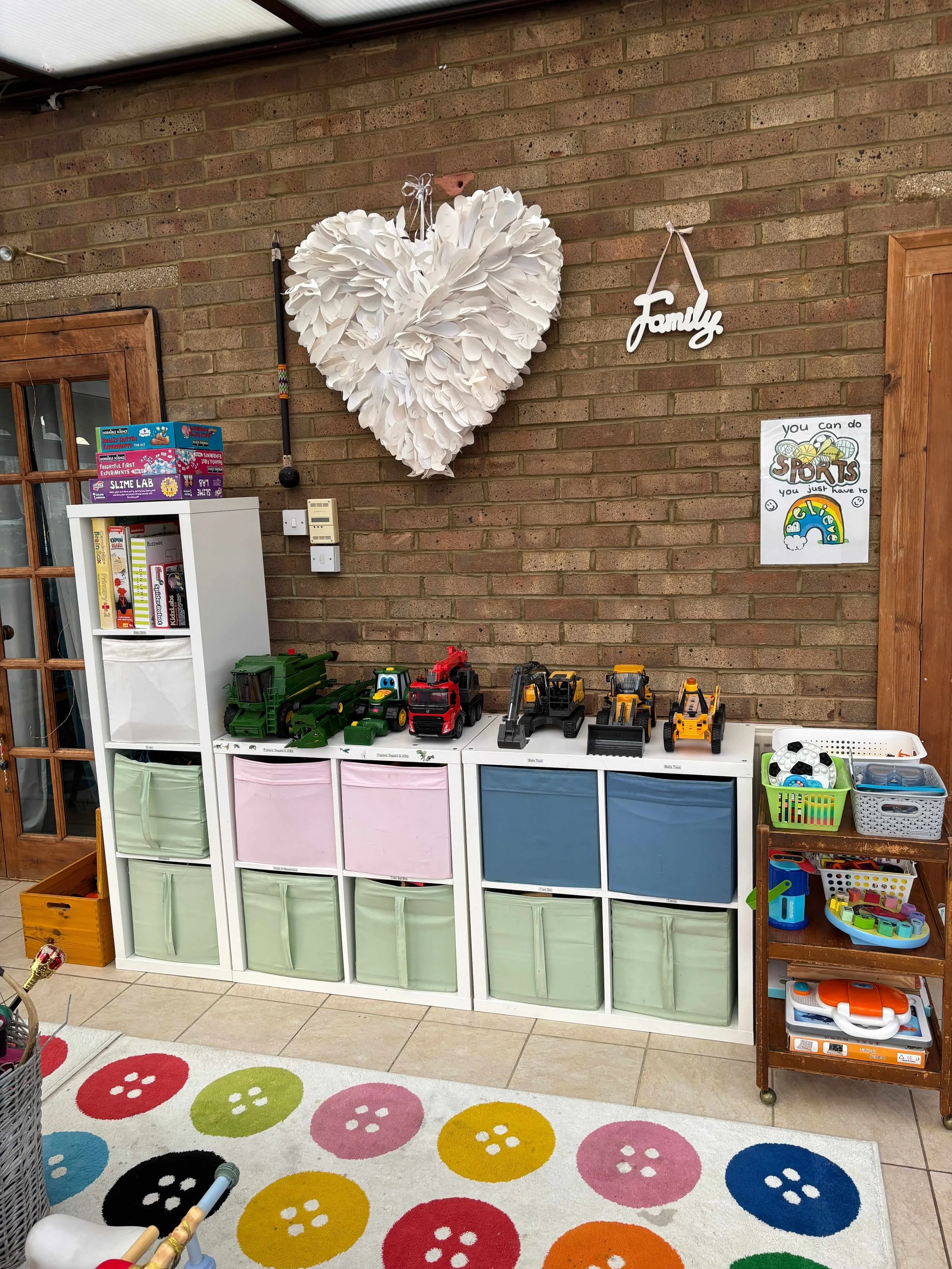 An organised children's playroom with IKEA kallax units and pull out drawers, the toys are all neatly tidied into the storage and they all have labels.