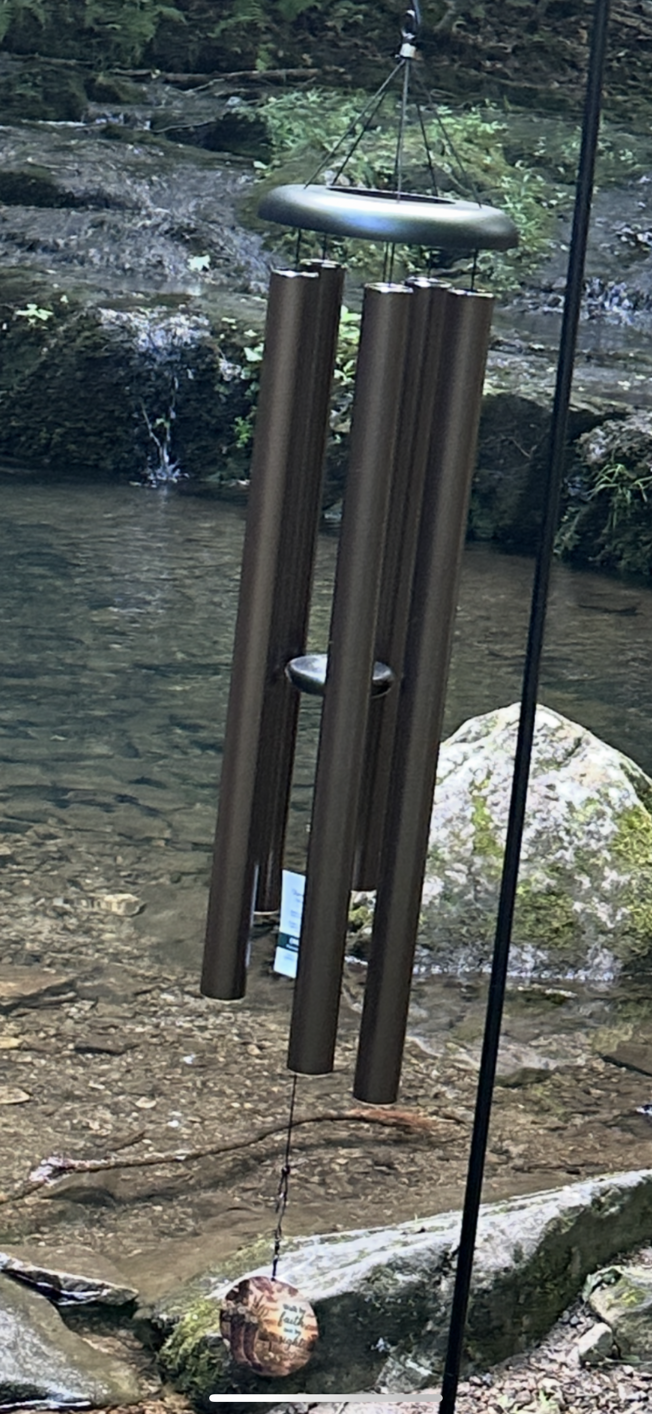 Classic Forever Near wind chime hanging in a natural outdoor setting.