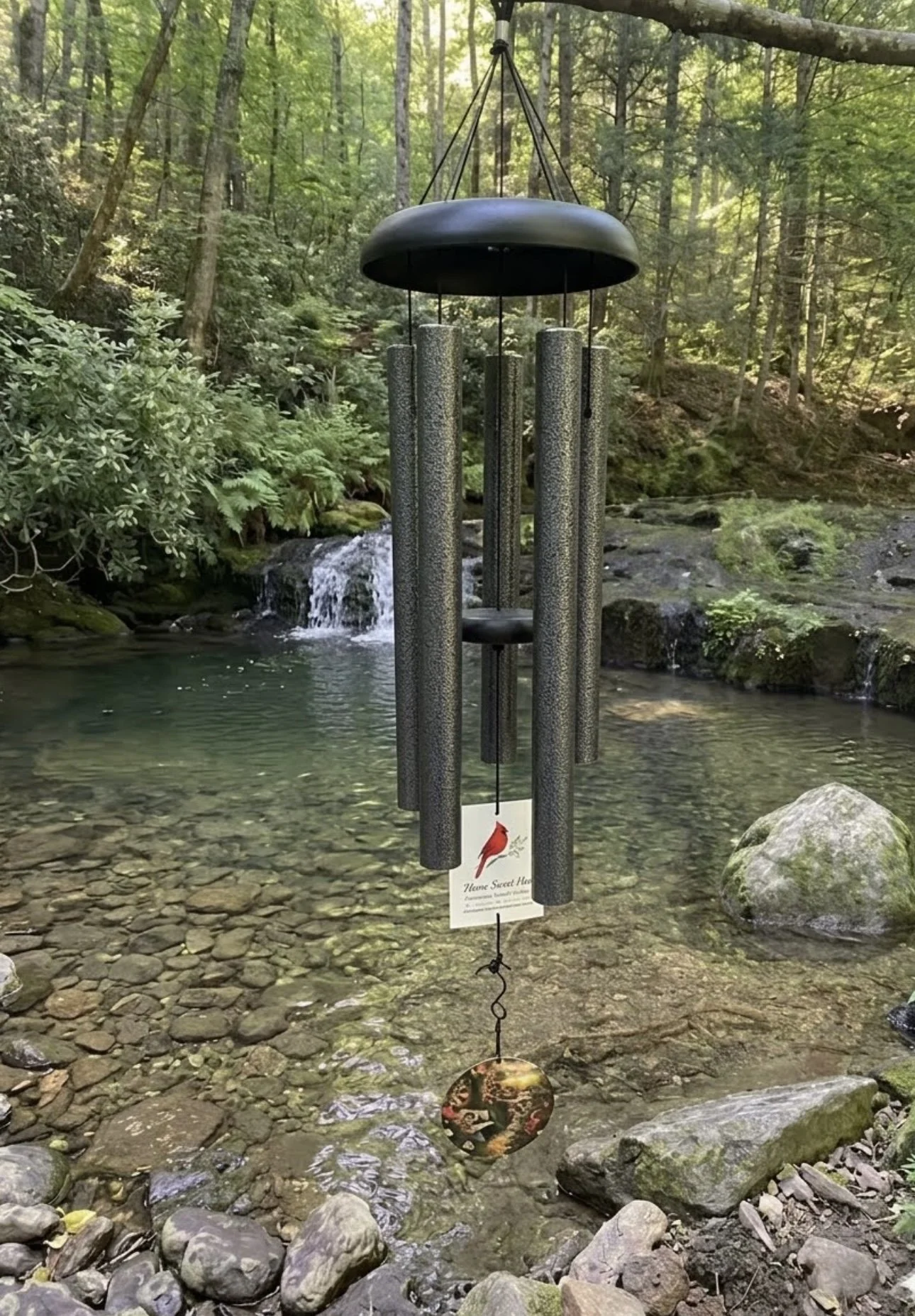 Forever Near wind chime hanging beautifully over a peaceful creek.