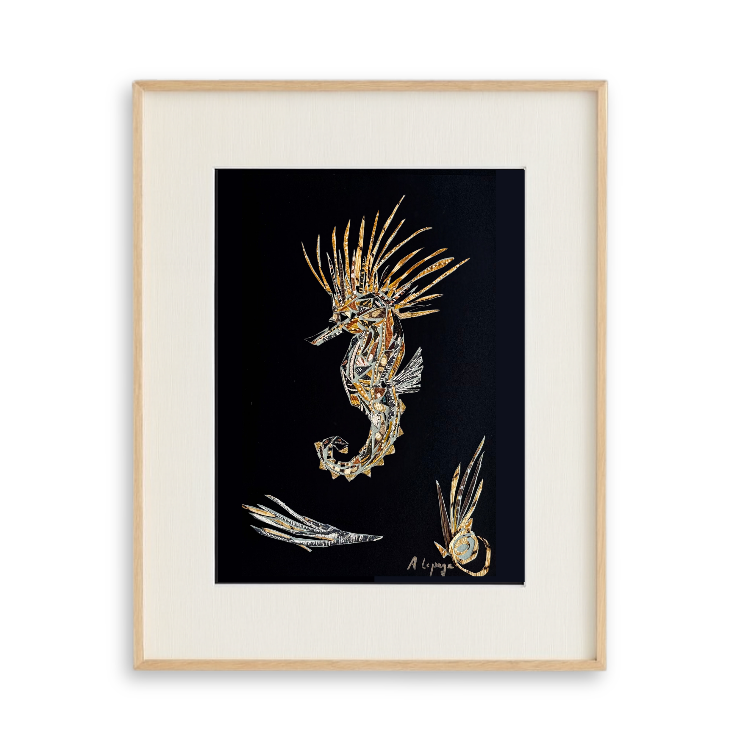 Une œuvre d'art représentant un hippocampe ornée de motifs dorés et argentés sur fond noir, encadrée dans un cadre en bois et une bordure blanche.