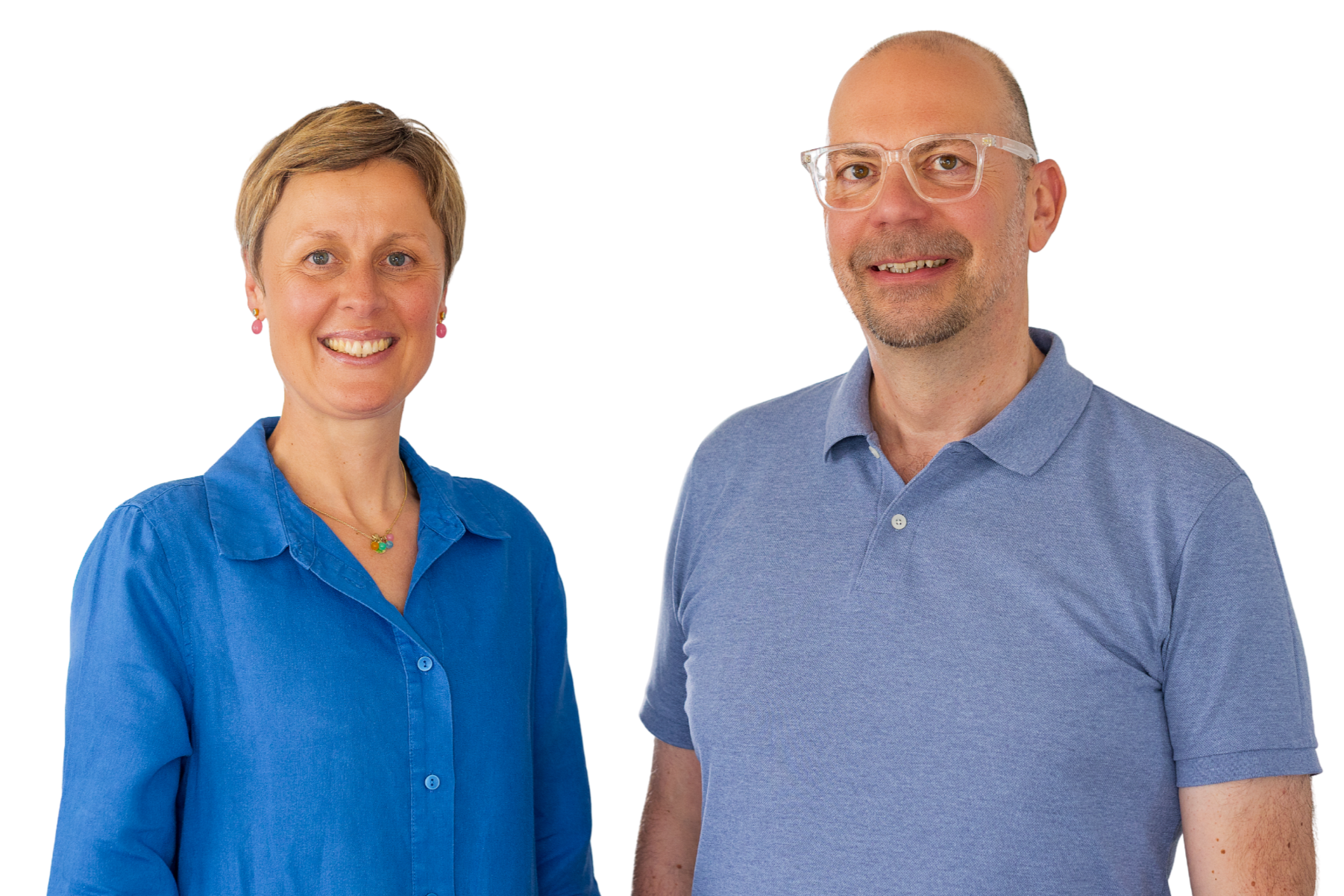 Ein Mann und eine Frau stehen nebeneinander und lächeln. Die Frau trägt eine blaue Bluse, der Mann trägt ein blaues Polo-Shirt. Beide schauen in die Kamera.