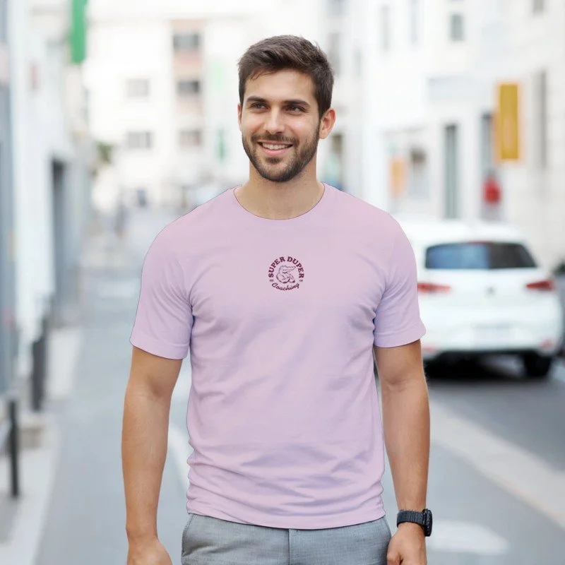 Un homme souriant marche dans une rue urbaine, portant un t-shirt lilas et un bracelet noir.