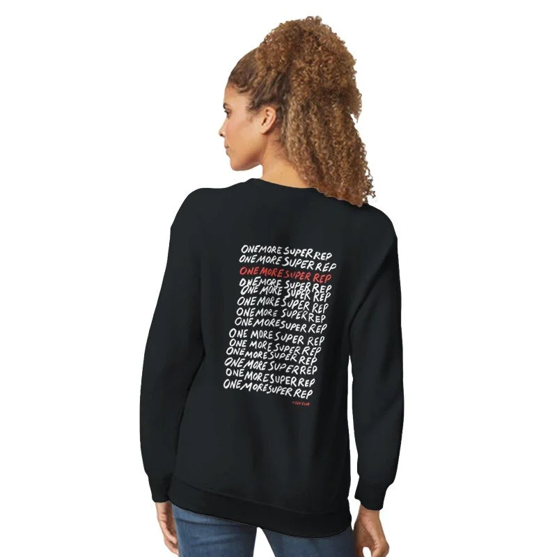 Femme portant un sweat noir avec le texte répétitif "ONE MORE SUPER REP" blanc et rouge au dos.