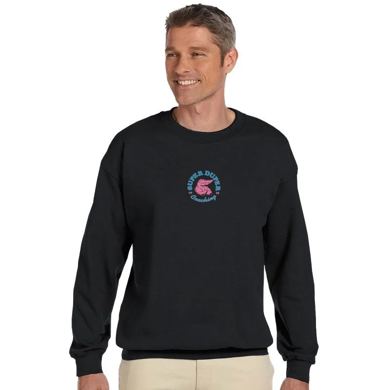 Un homme souriant portant un sweat noir avec un logo au centre représentant une tête de dromadaire rose et du texte "Duper Dune" et "Goodvibes".