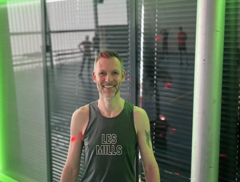 Vrolijke man in sportkleding in een sporthal.