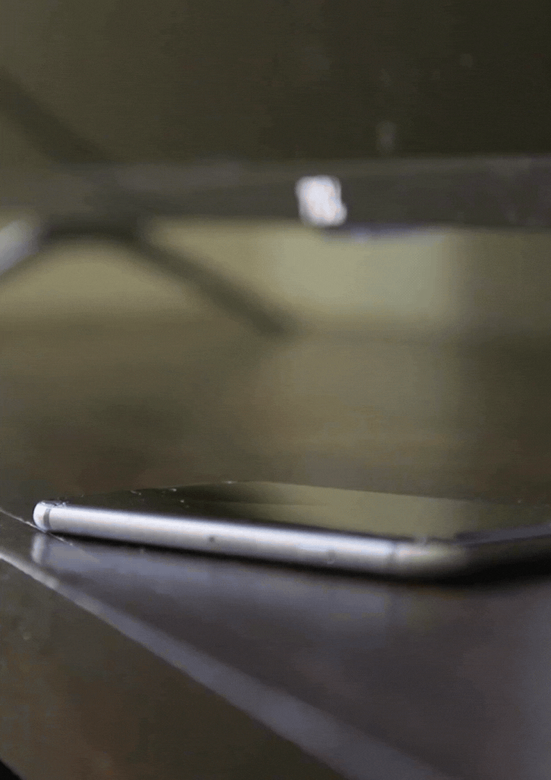 Close-up of a smartphone lying flat on a dark wooden surface with a blurred background.