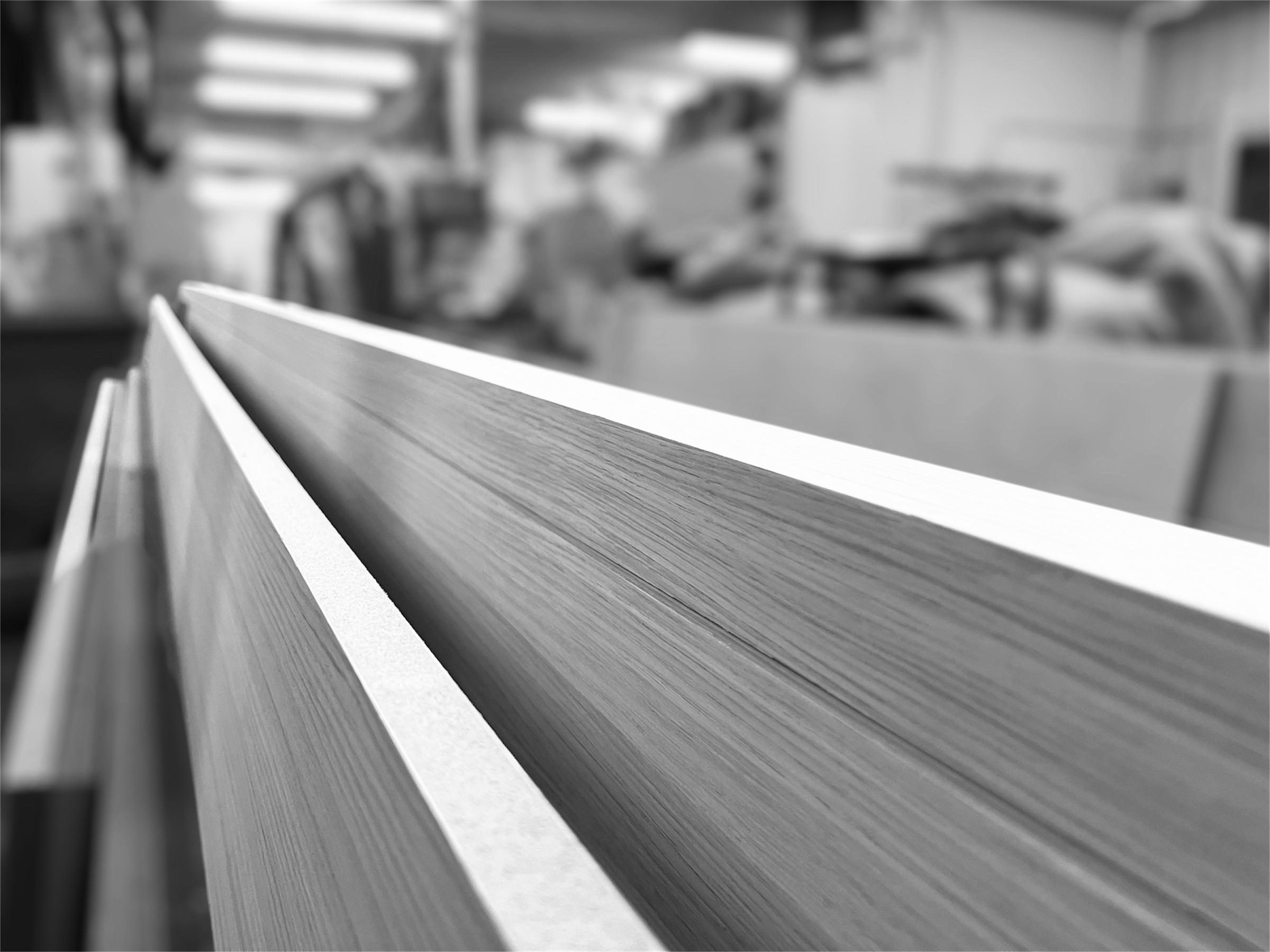 Close-up of a premium hard wood seen from the edge in a blurred indoor setting.