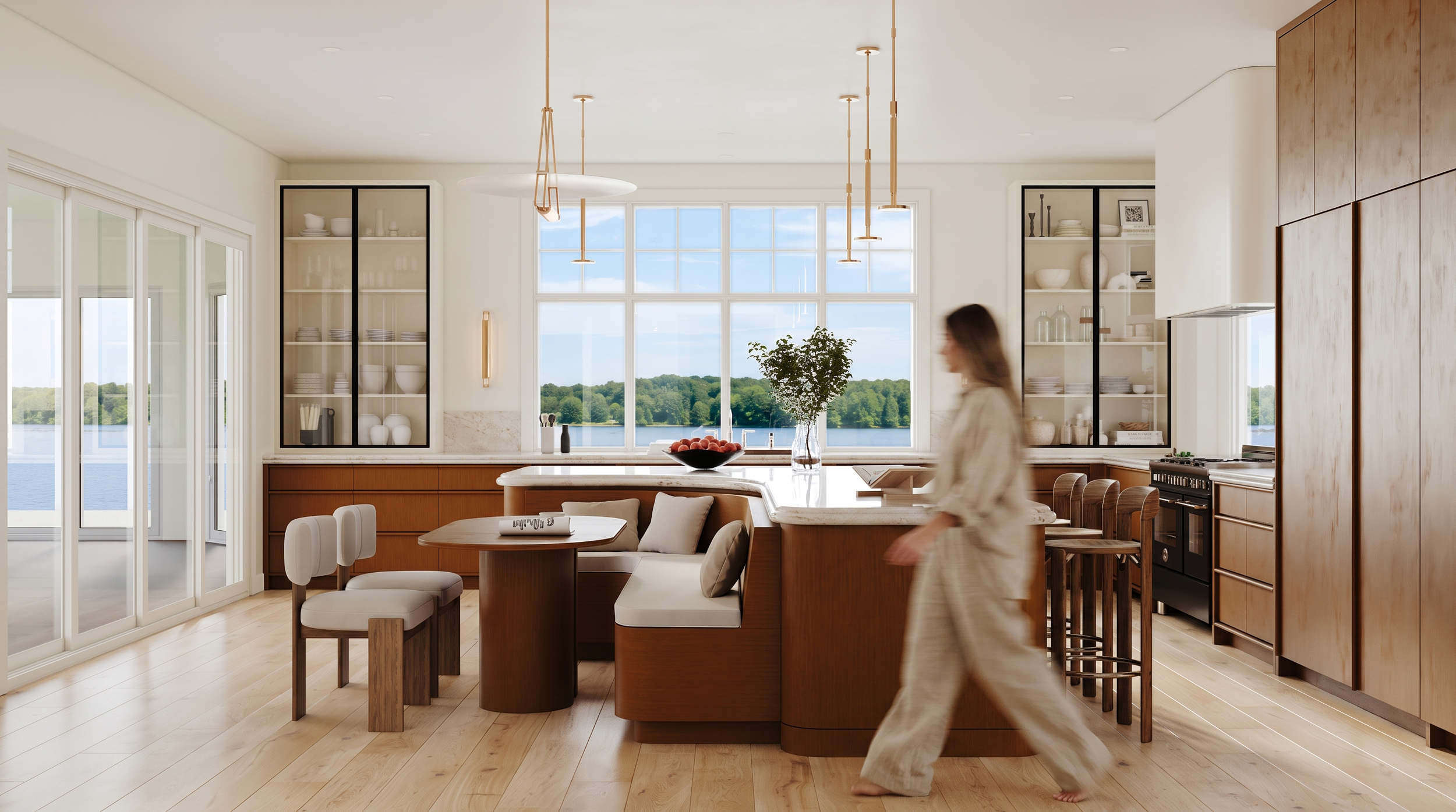 Modern kitchen with large window overlooking a lake, featuring wooden cabinets, open shelving, a dining table, and a woman walking through the space.