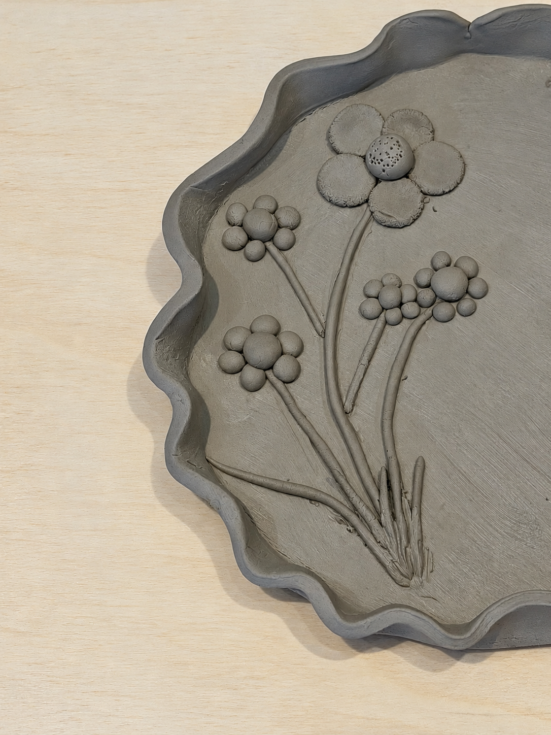 Handgeformte Tonblumenschale auf Holz.png