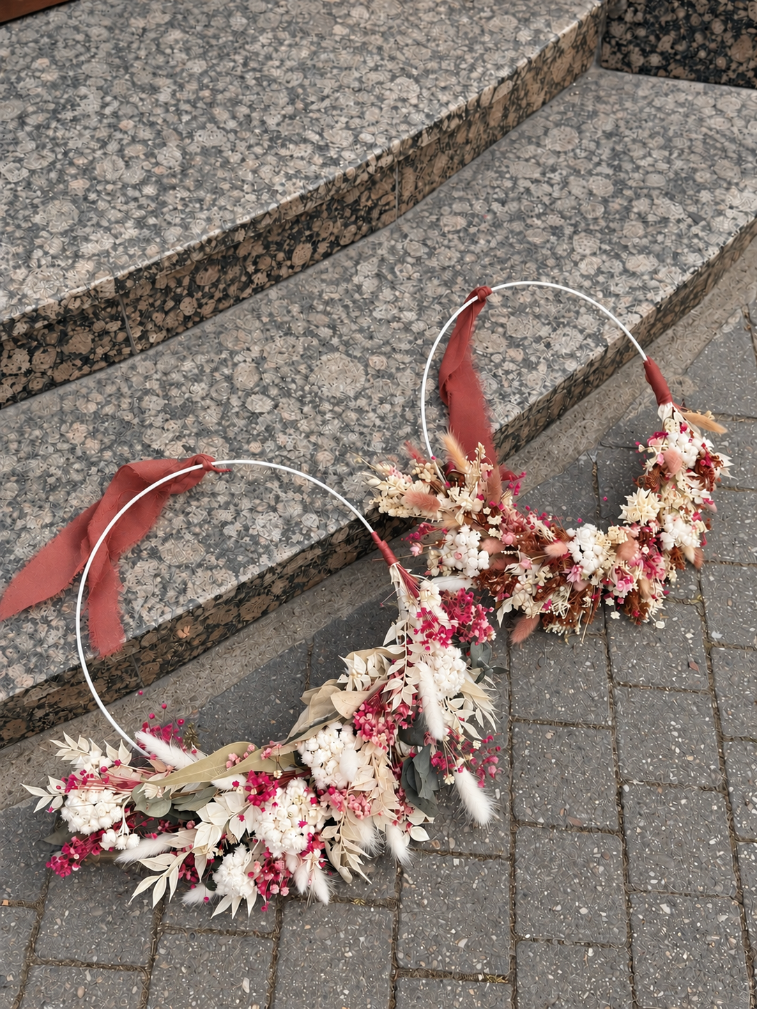 Floraler Doppelring auf Steinstufen.png