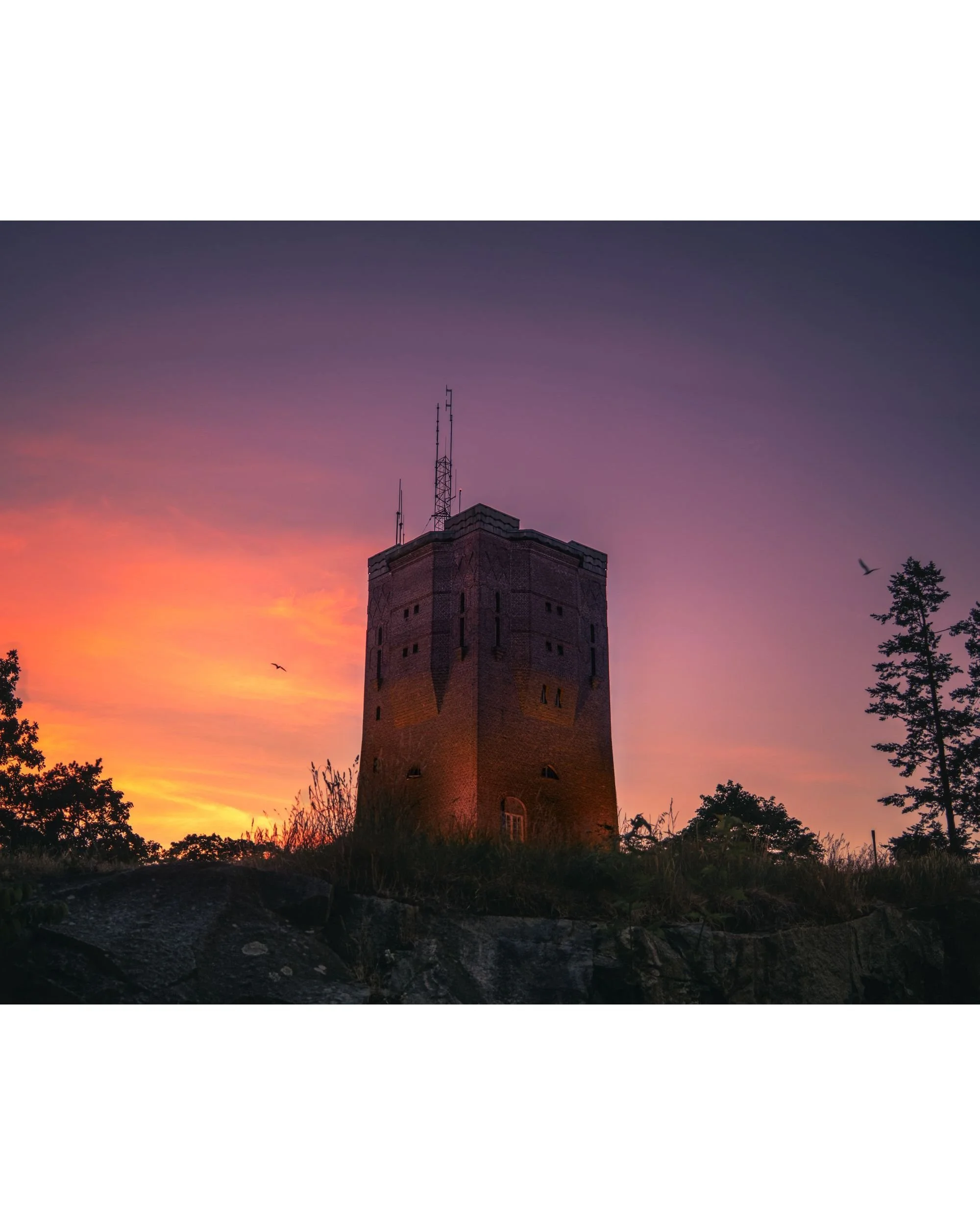 Sundbyberg water tower silhouetted against a dramatic pink and purple sunset sky — fine art cityscape photography print