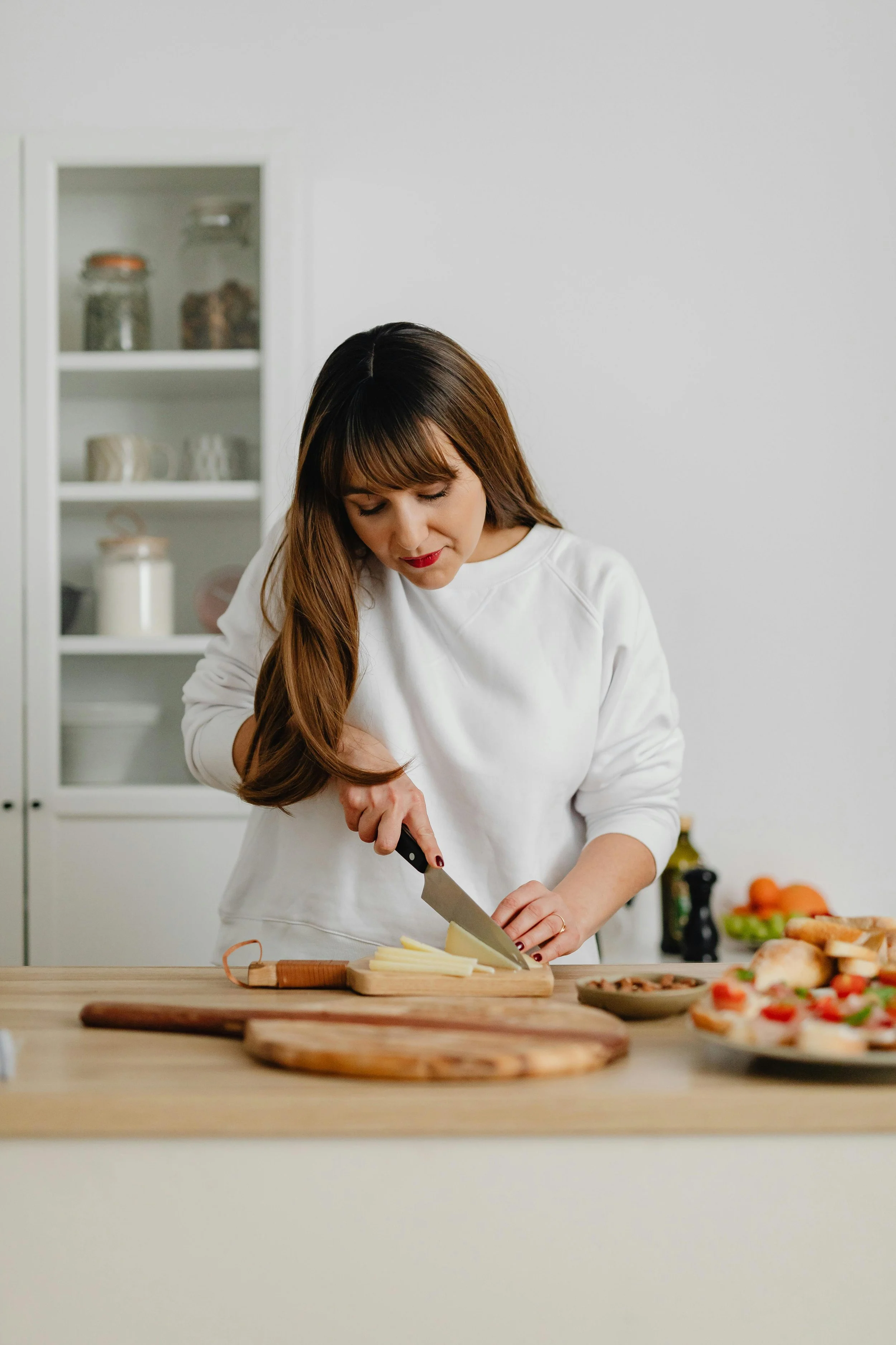 Woman standing in a kitchen chopping vegetables, representing reconnection, mindfulness, and everyday healing after trauma.