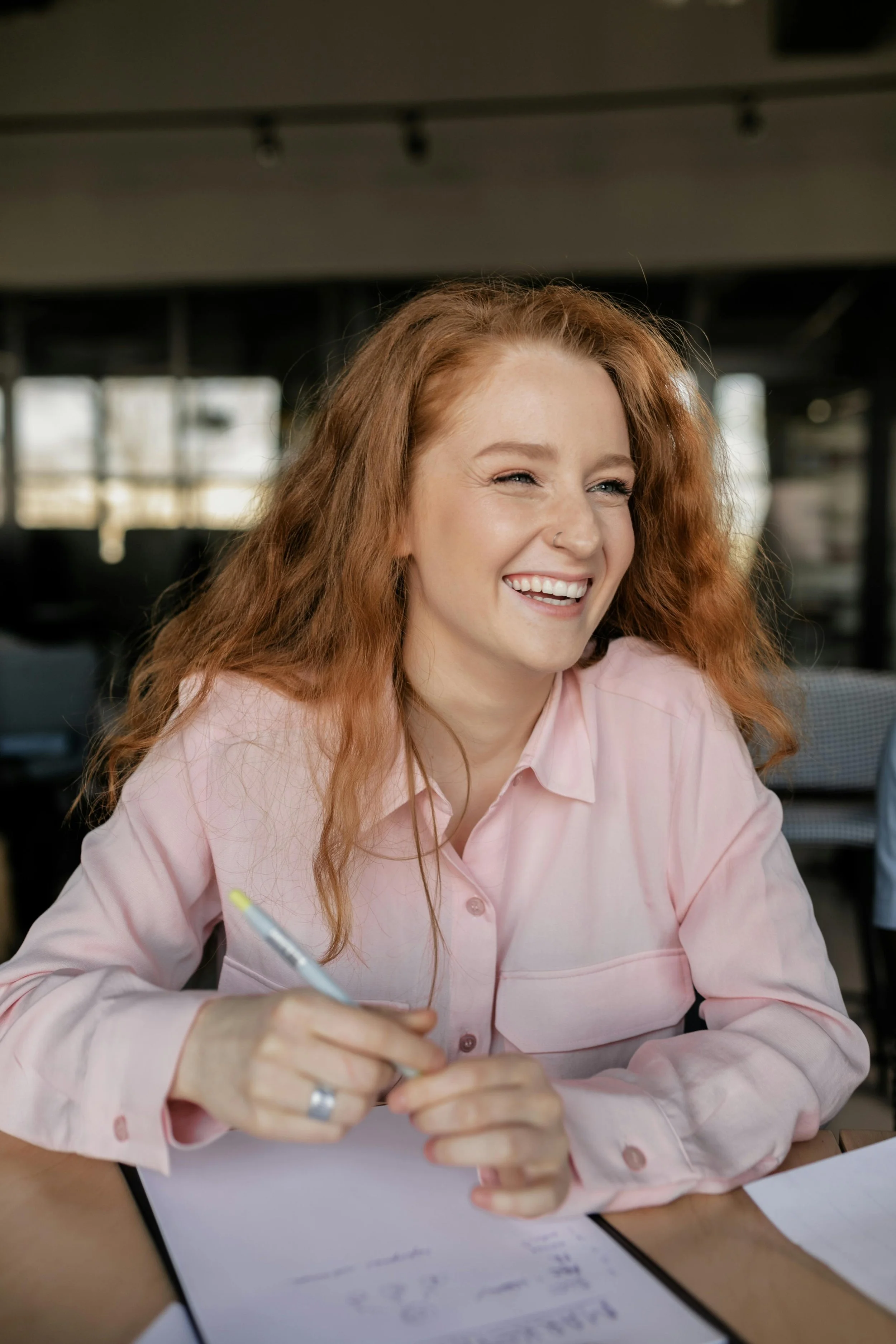 Woman smiling while journaling during therapy, representing awareness and self-compassion in depression recovery.