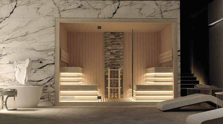 Spa o sauna con sedili illuminati in legno, pareti di pietra e un'area relax con sedie e una fonte in marmo.