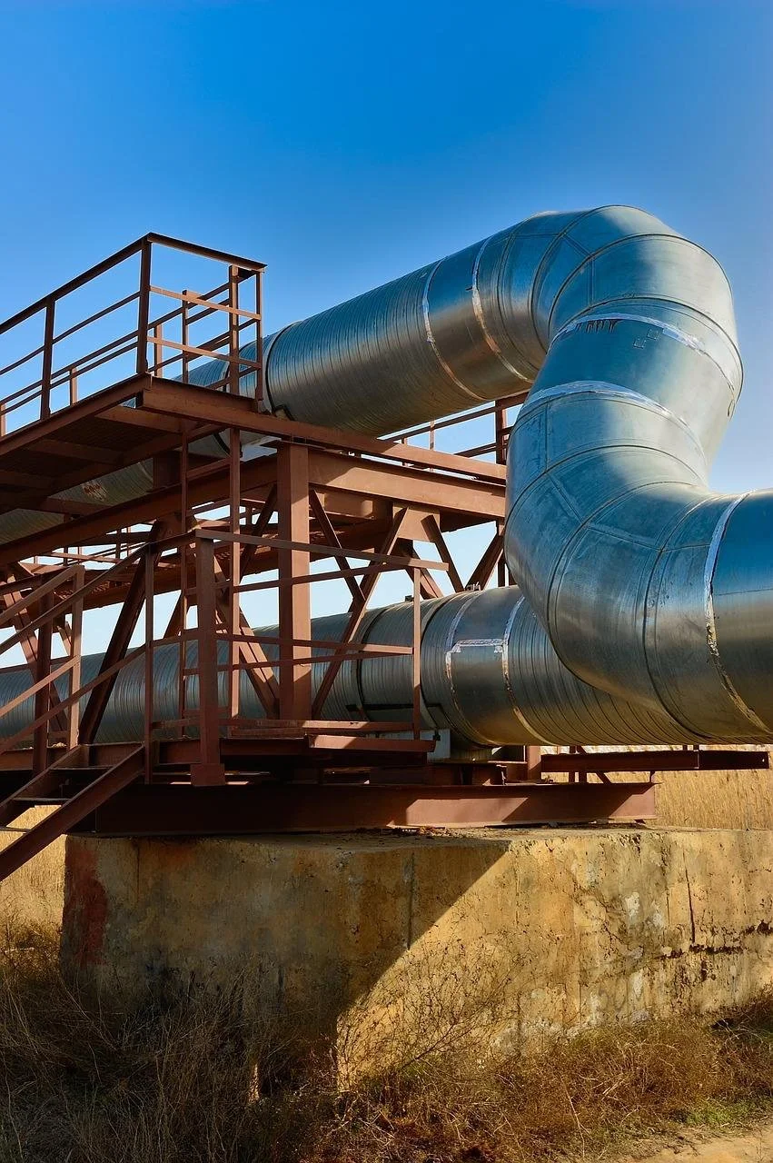 Große Stahlleitung auf einer Metallplattform unter blauem Himmel