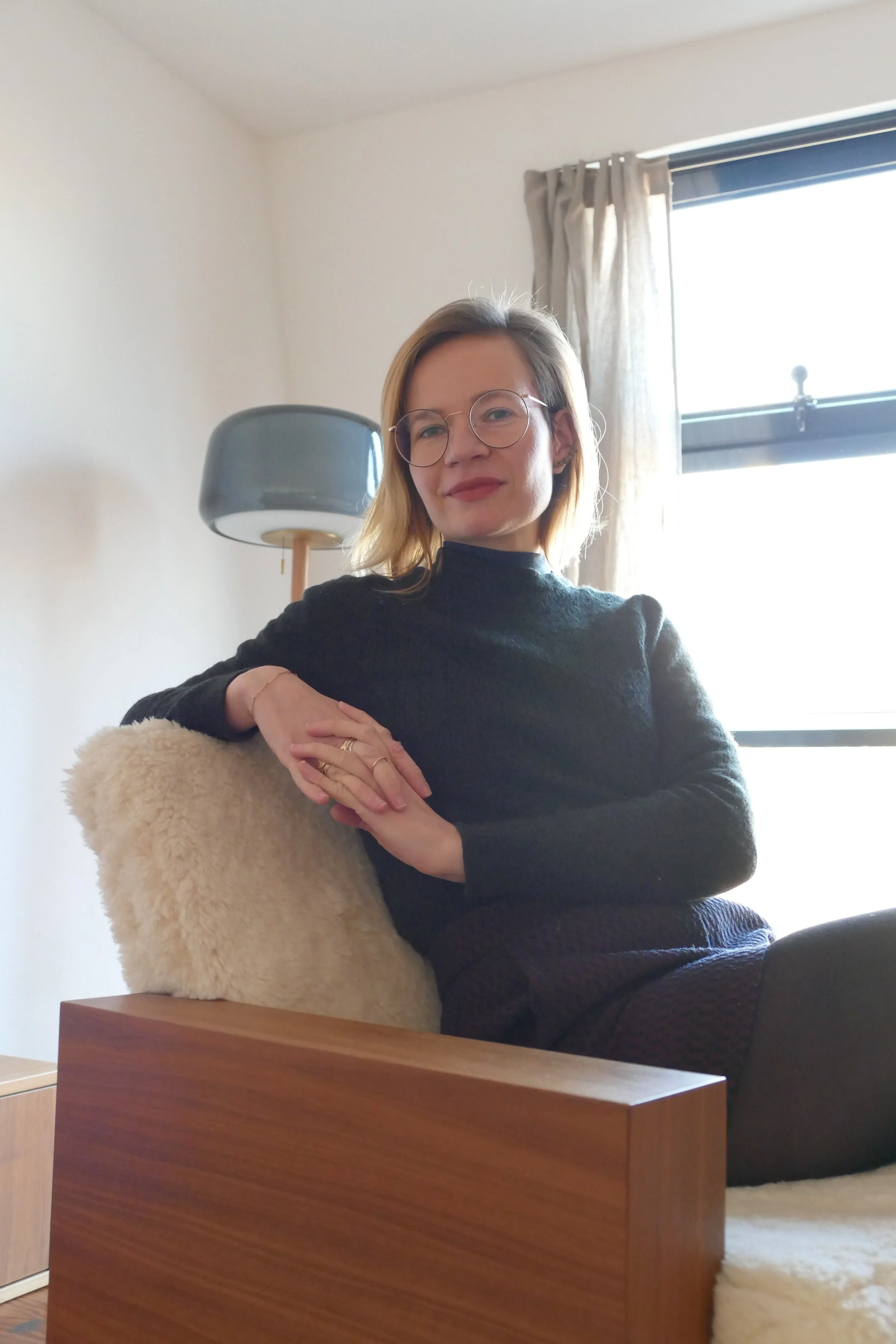 Portrait von Lina Winkler-Busch, die auf einem gemütlichen Sessel im hellen Therapie-Raum sitzt.