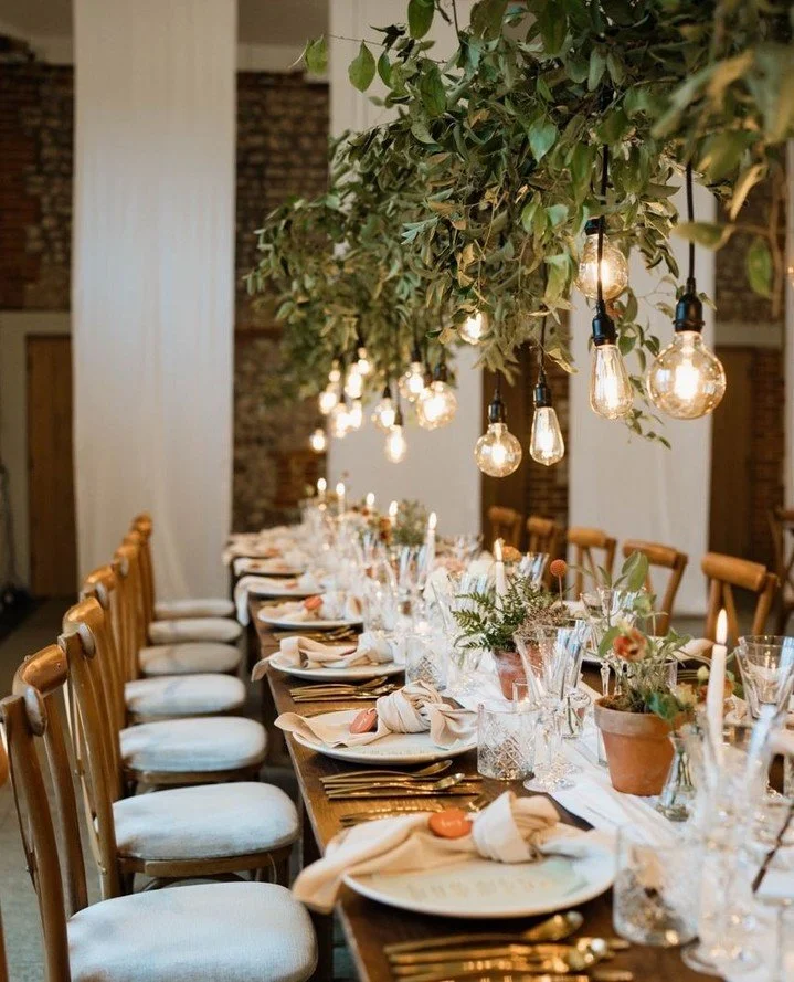 By combining natural foliage installations with warm festoon lighting, you can create a striking overhead feature that draws the eye, adds depth, and brings a soft, intimate glow to long banquet tables.⁠
⁠
Photography - @kellyrebeccaphotography⁠
Desi