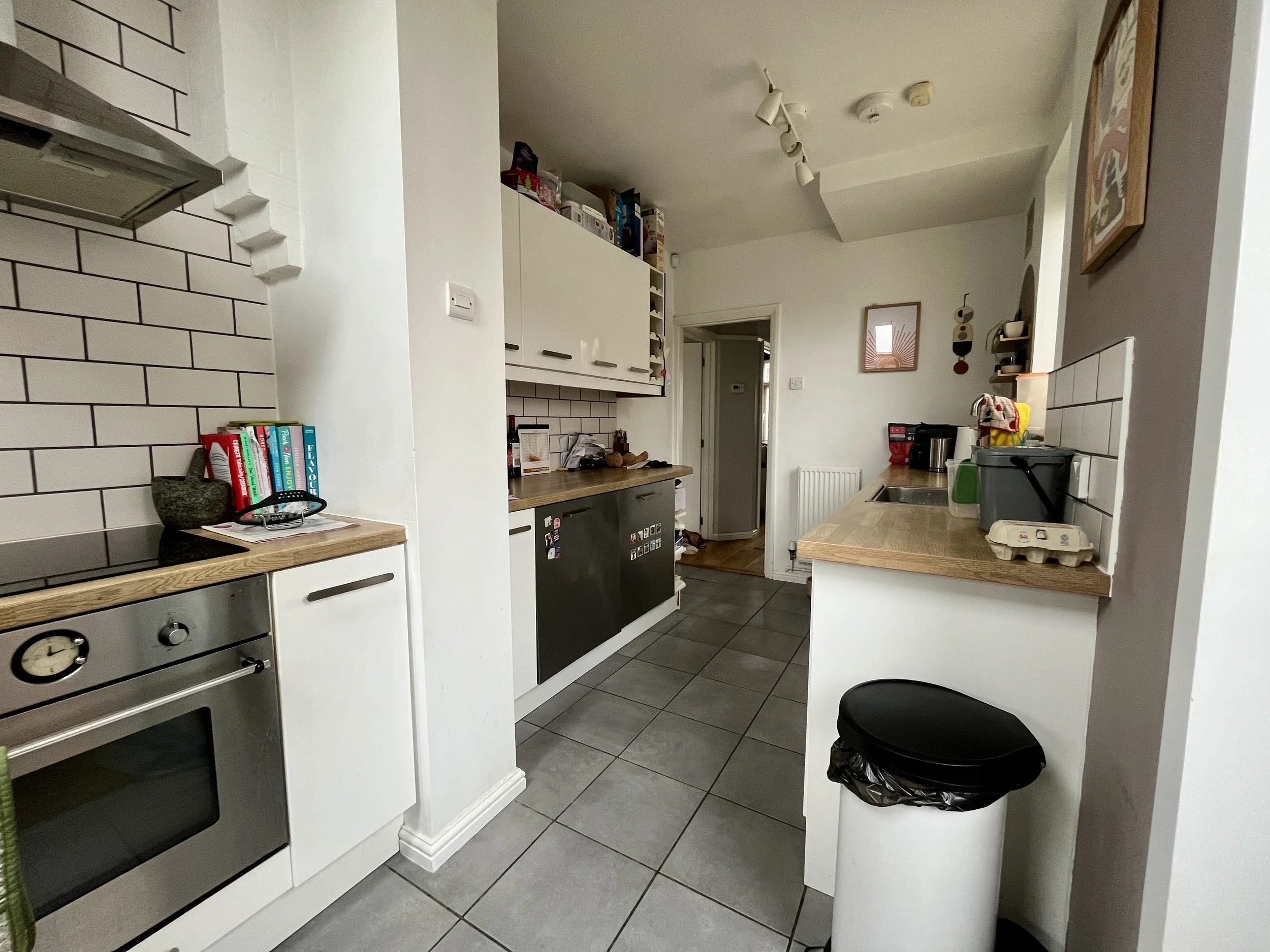 Now capture a wide-angle photo from the opposite side of the kitchen. This shot should show the full run of cabinets, counters, and any features from that perspective. Ensure good lighting so we can see all surfaces clearly
