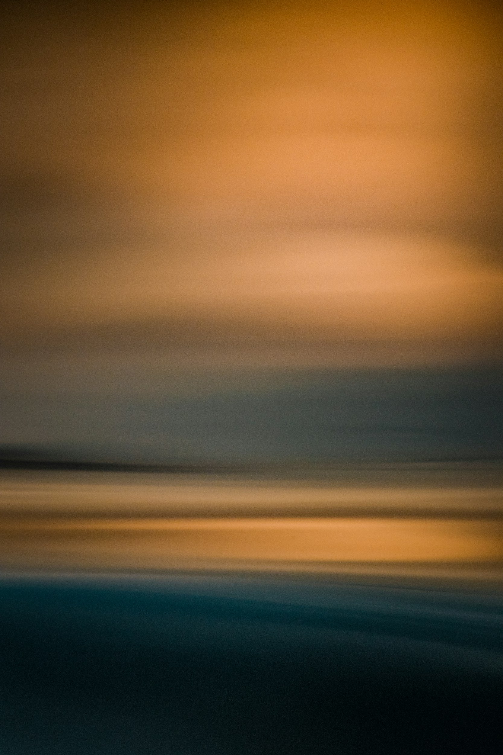 An abstract image with blurred horizontal lines in shades of orange, yellow, blue, and black