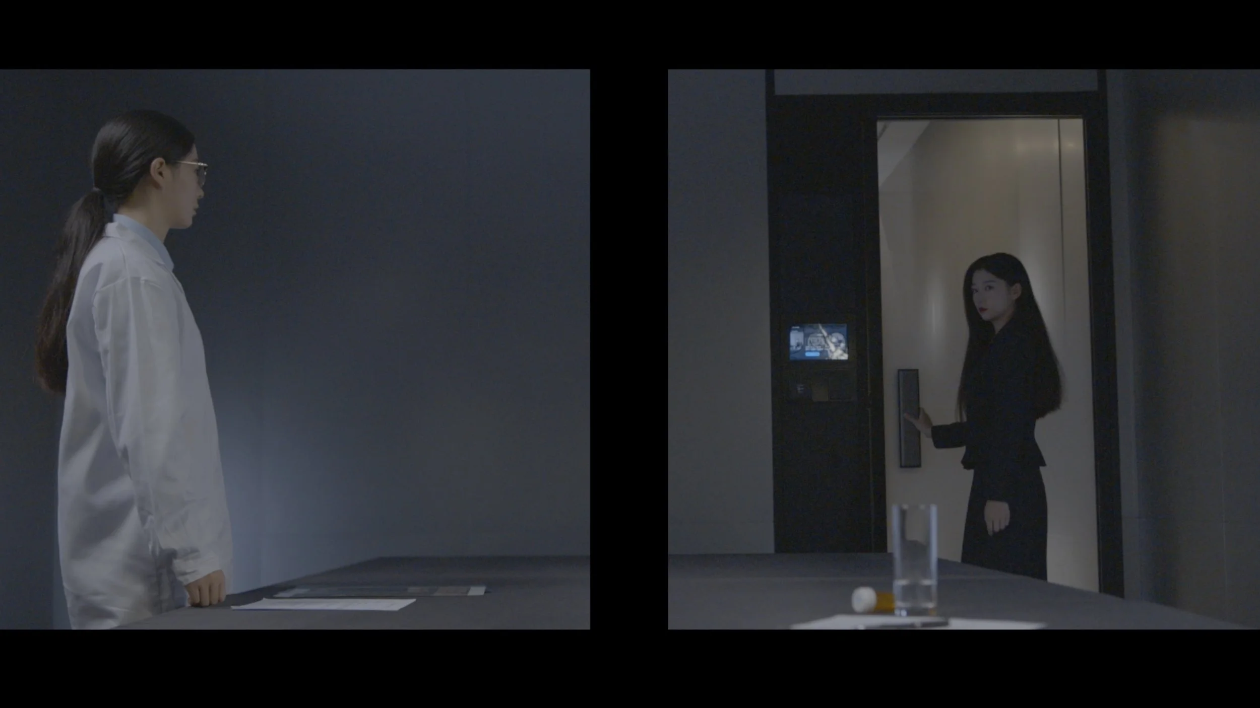 Two women facing each other in a split-screen image. The woman on the left, wearing glasses and a white coat, stands next to a table. The woman on the right, dressed in black, stands by an elevator, holding her phone, with a drink, pill, and tablet on the table in the foreground.