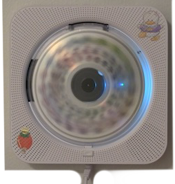 A top-down view of a white iPod with colorful cartoon stickers, including a strawberry and an ice cream cone, on a white surface.