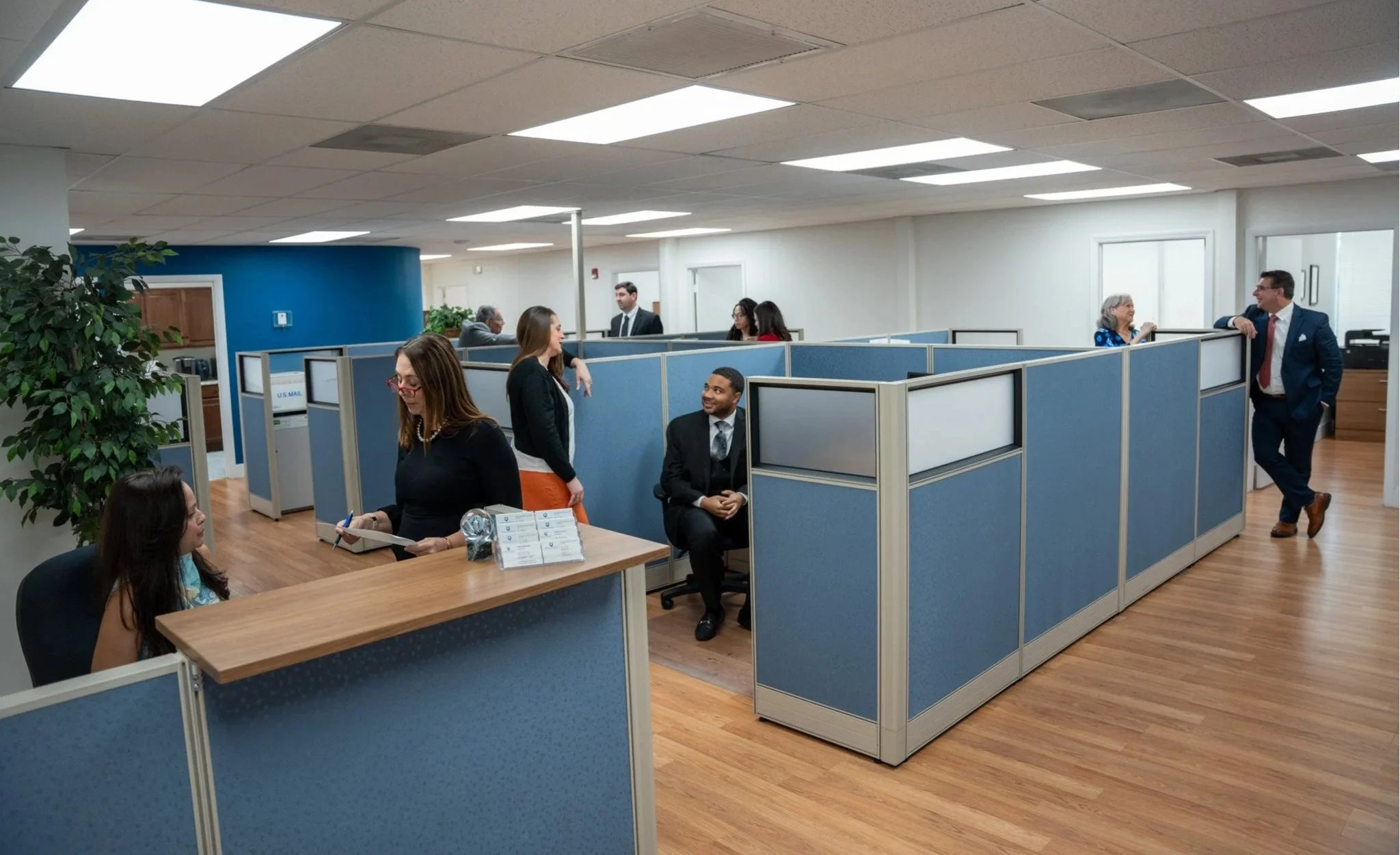 Candid photo of the Paladin Office people chatting at their cubicles