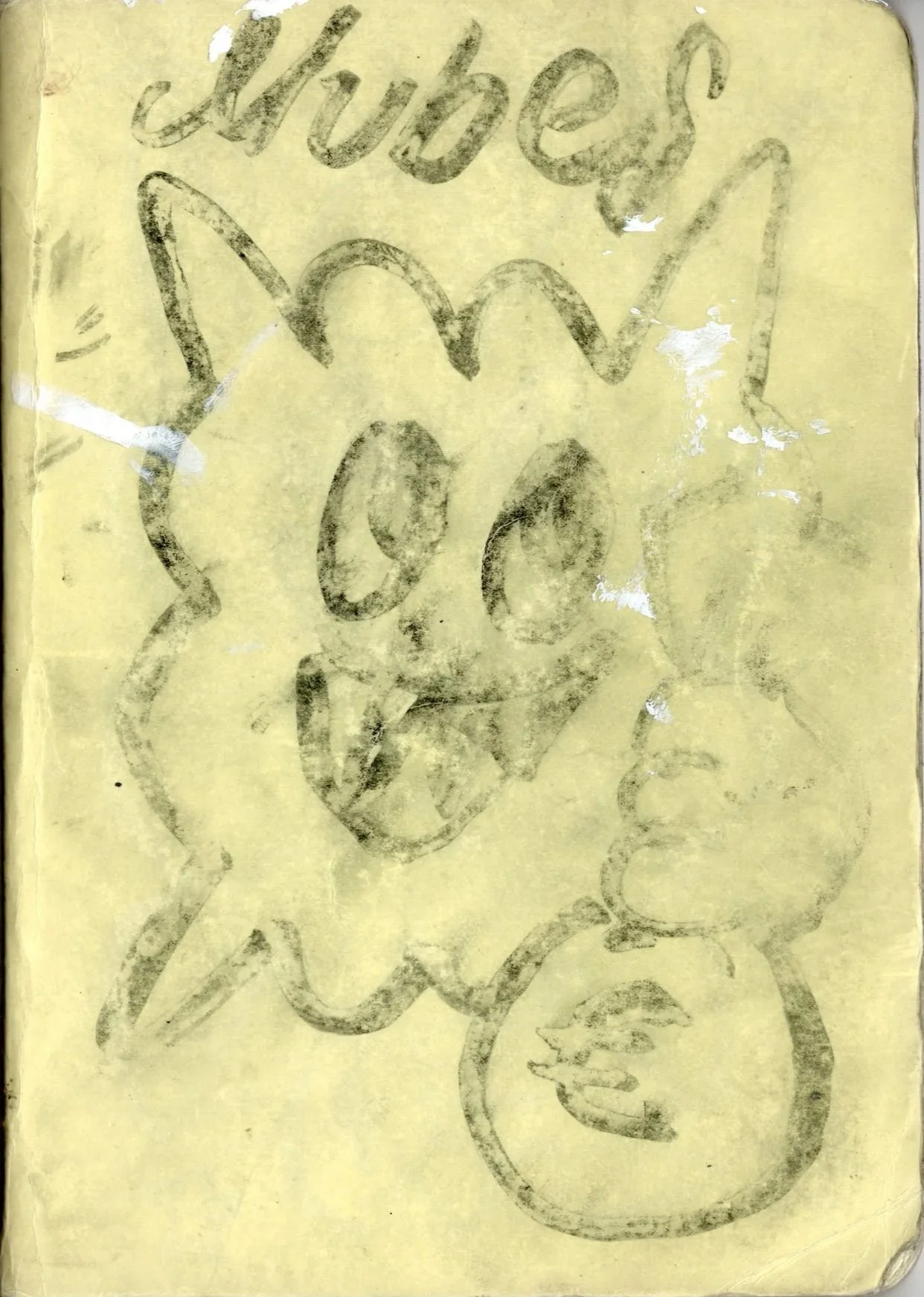 Dibujo en papel amarillo con una cara sonriente, orejas puntiagudas y una lengua afuera, acompañado de la palabra 'subscribe' en la parte superior.