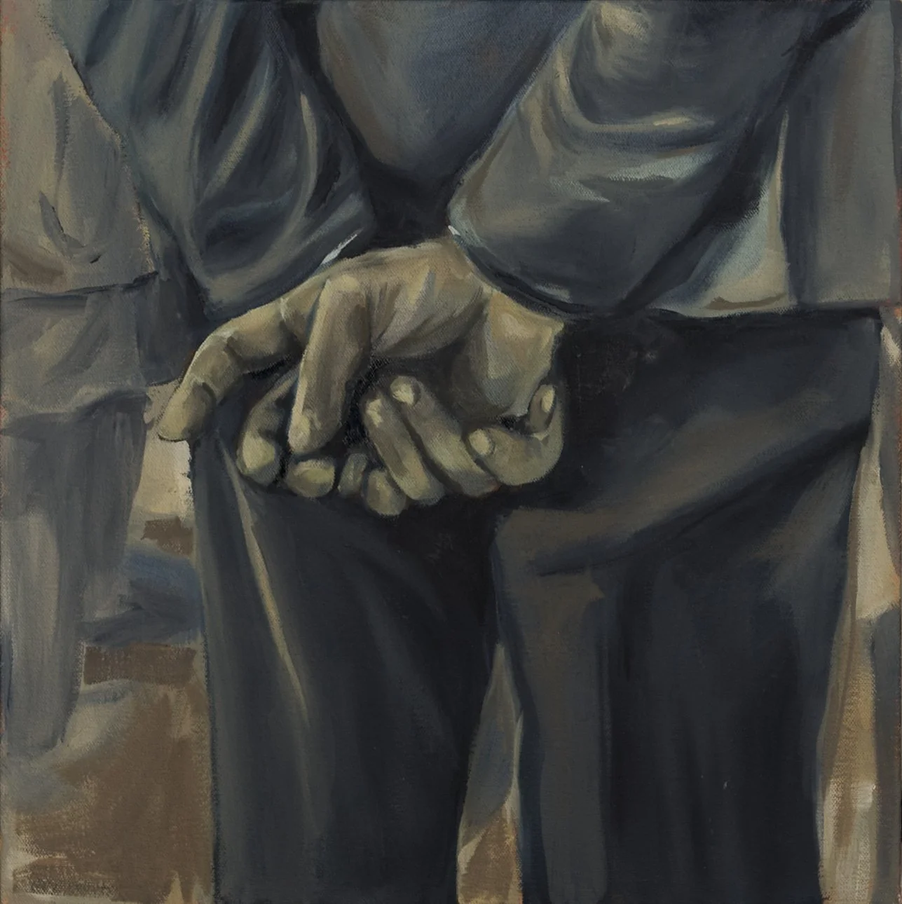 Mano entrelazada en el cinturón, vista de torso y pantalón oscuro.