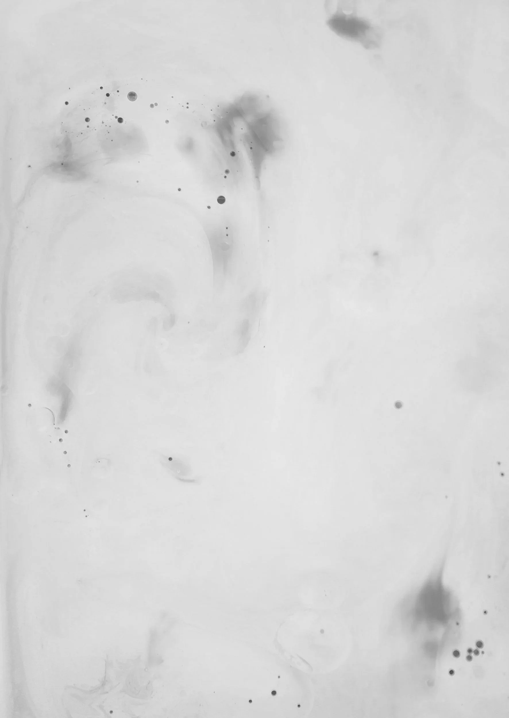 Abstract black ink splash on white background with scattered ink droplets.