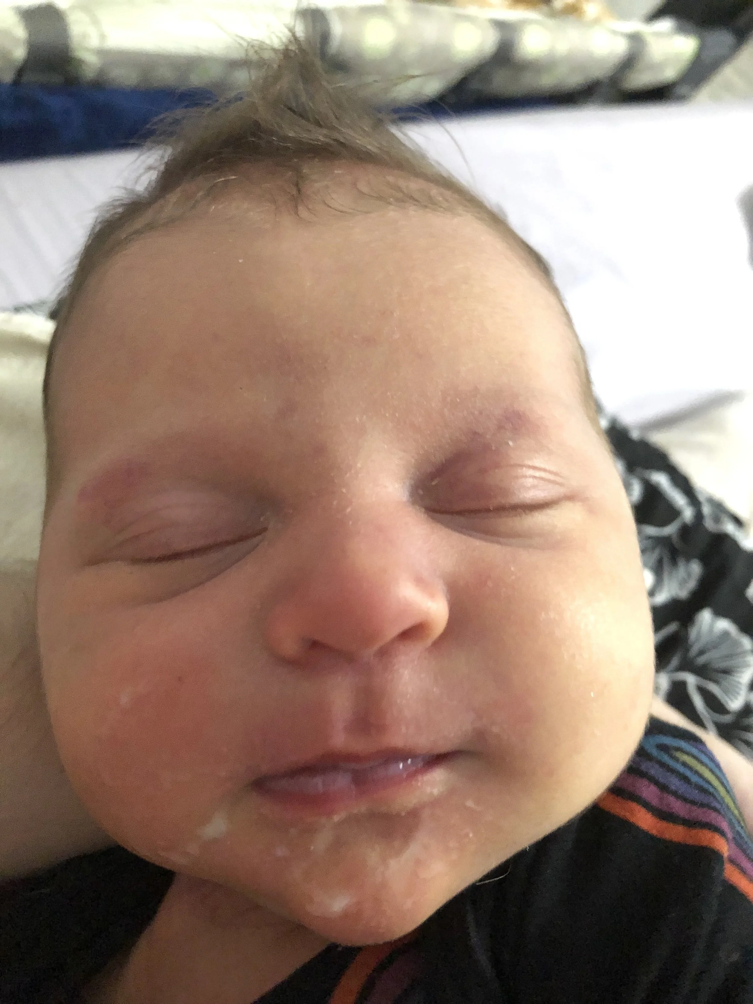 Close-up of a baby's face peacefully sleeping, with eyes closed and relaxed facial features.