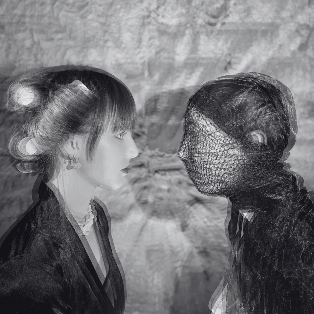 A black and white photo of two women facing each other, one with styled hair and wearing earrings and a pearl necklace, the other with her head wrapped in black fabric and lace, against a textured background.
