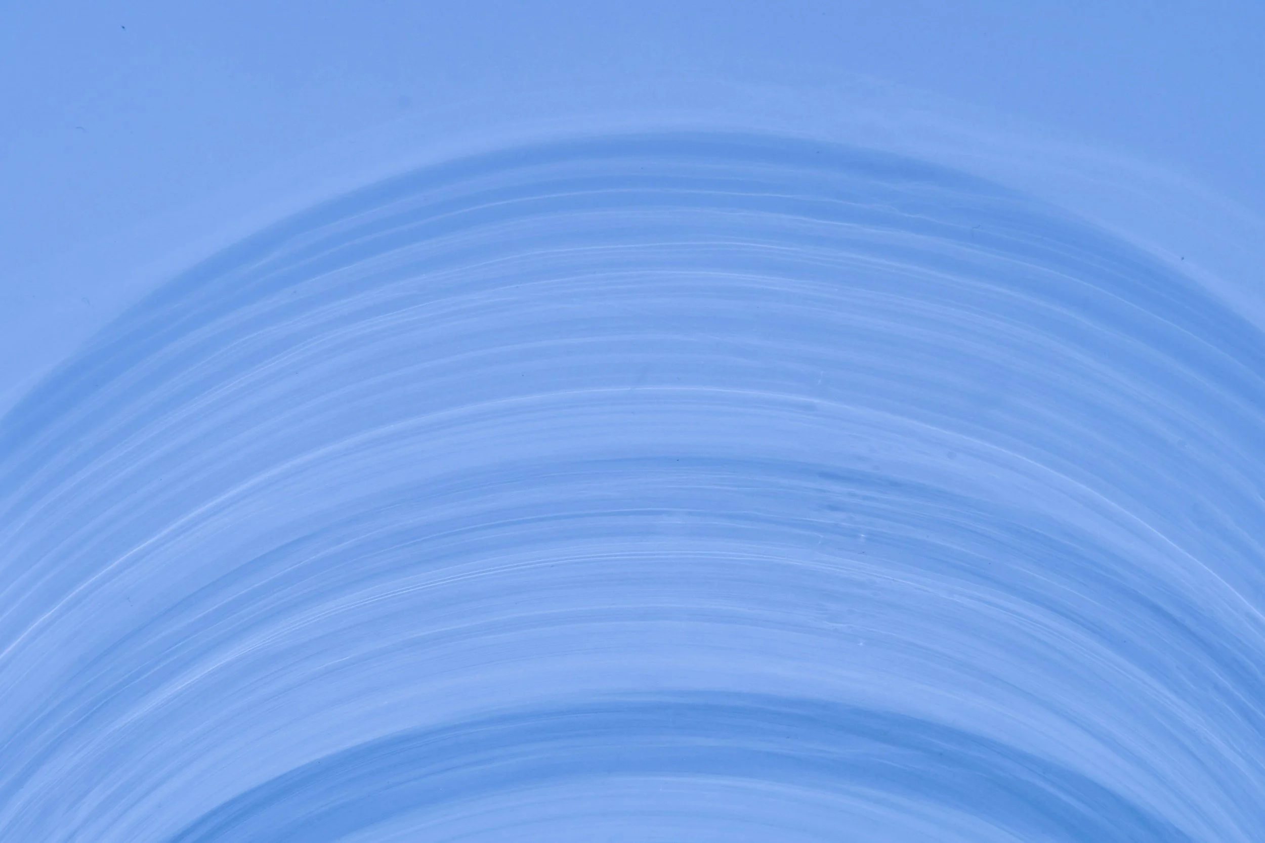 Close-up view of a paint roller applying light blue paint on a surface with visible brush strokes.