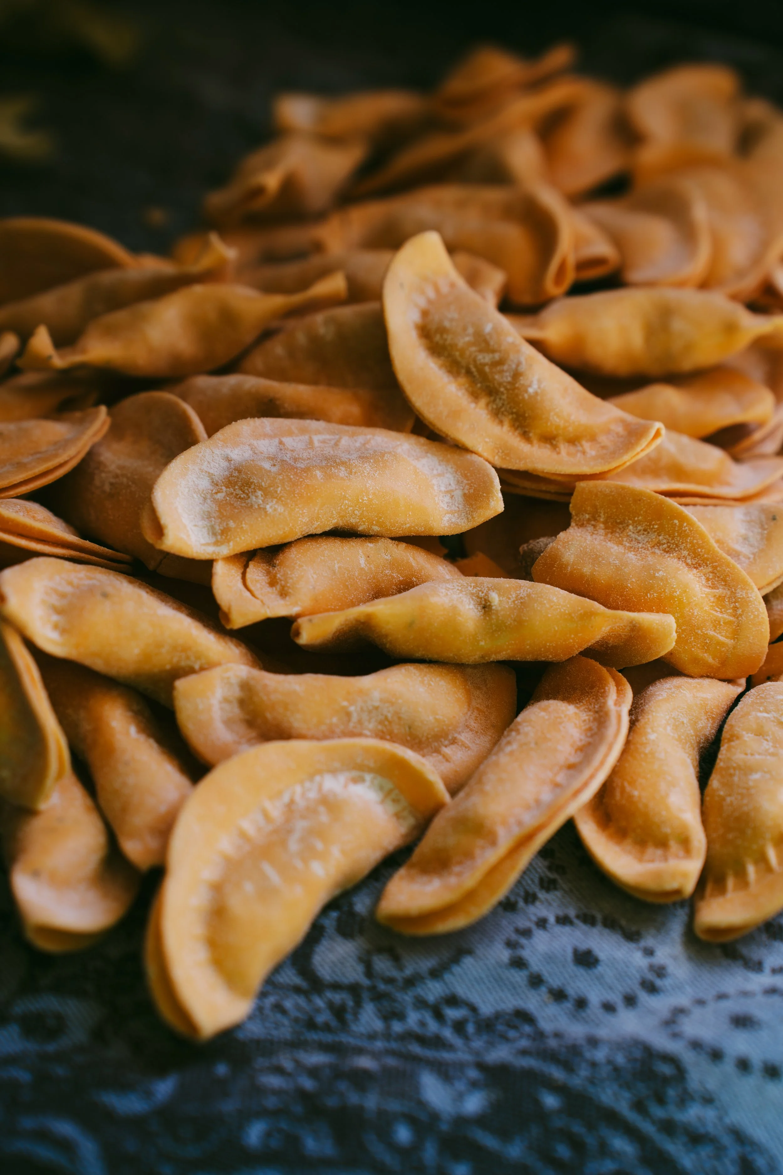 Close-up of frozen tortellini pasta on a black surface.