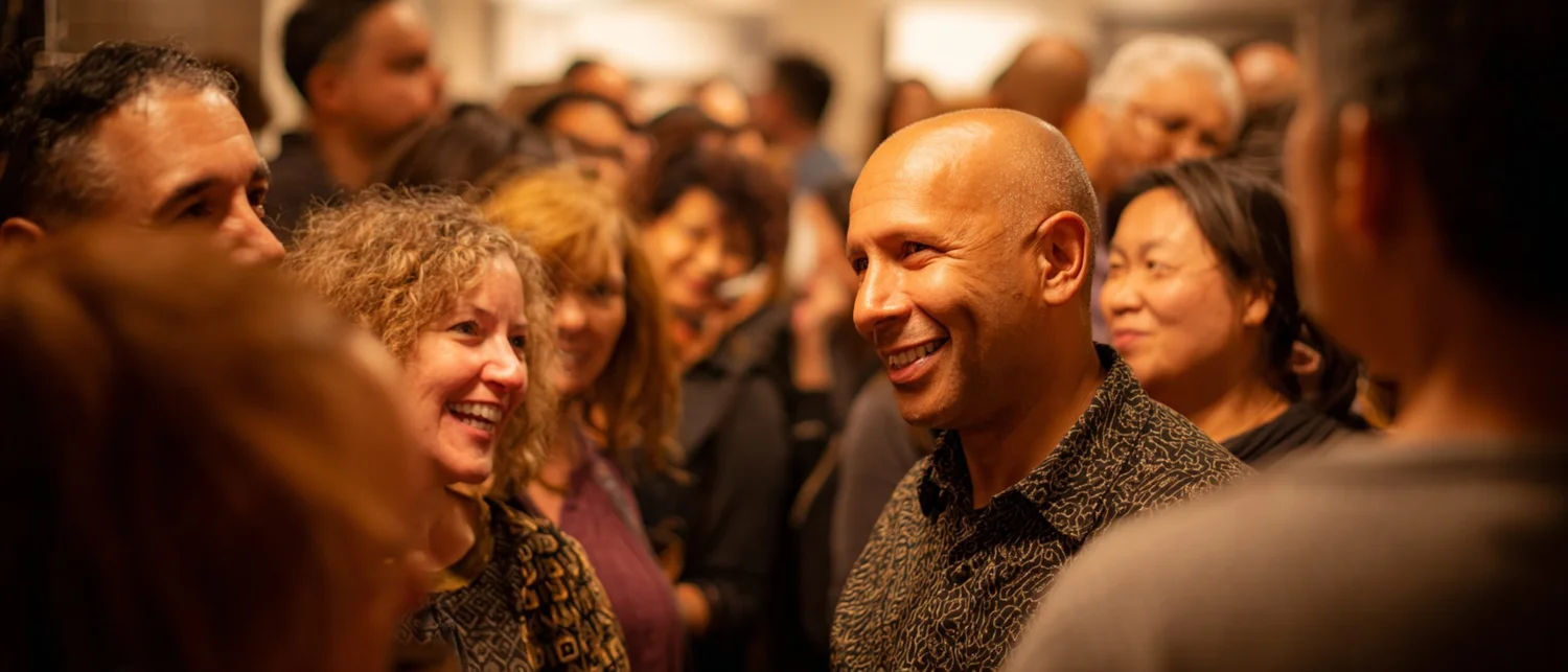 Guests gathering at a private event in a historic Baltimore venue with exposed brick and warm lighting