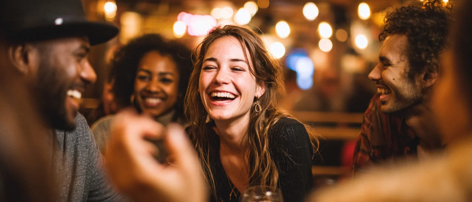 Evening celebration with close friends at a stylish bar with cocktails and candles