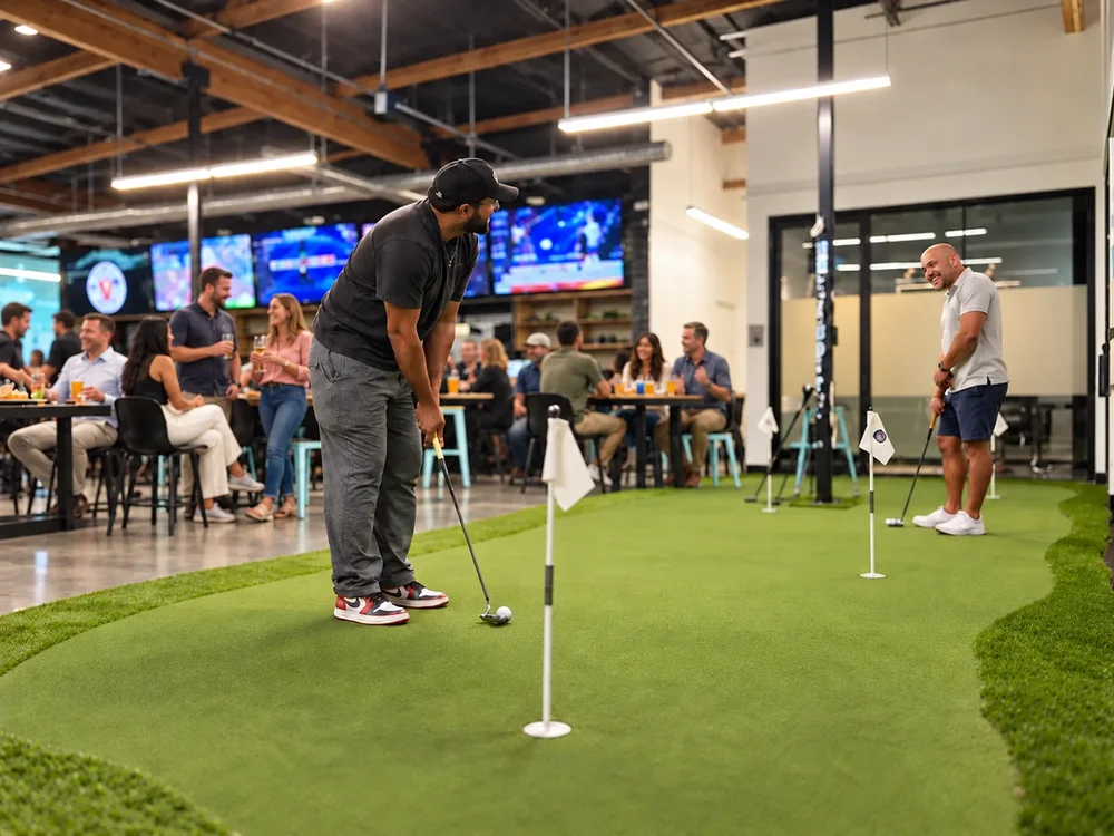A guest putting on the indoor green while others watch from their tables