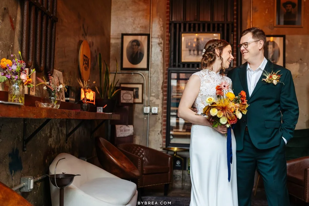 A couple in the Whiskey Lounge with a bouquet of autumn flowers
