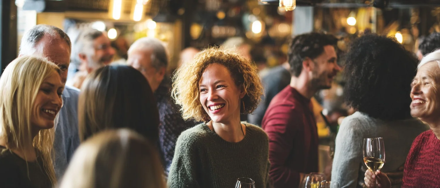 Guests at a cocktail reception in a gallery space with artwork on the walls and passed appetizers