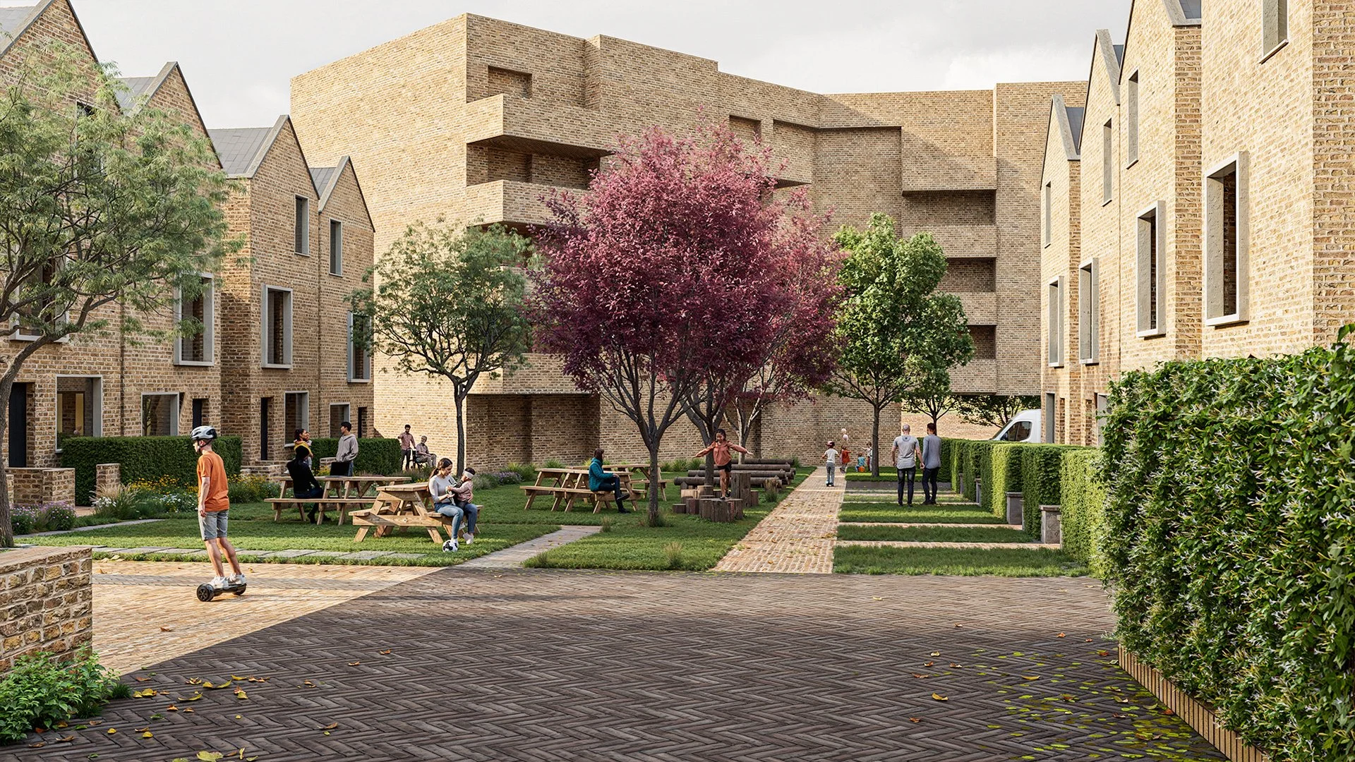 Residential courtyard visualisation showing modern brick buildings with pitched roofs, landscaped green spaces, trees with mixed foliage, paved walkways, and communal seating areas. People are socialising, walking, and using the space, creating a liv