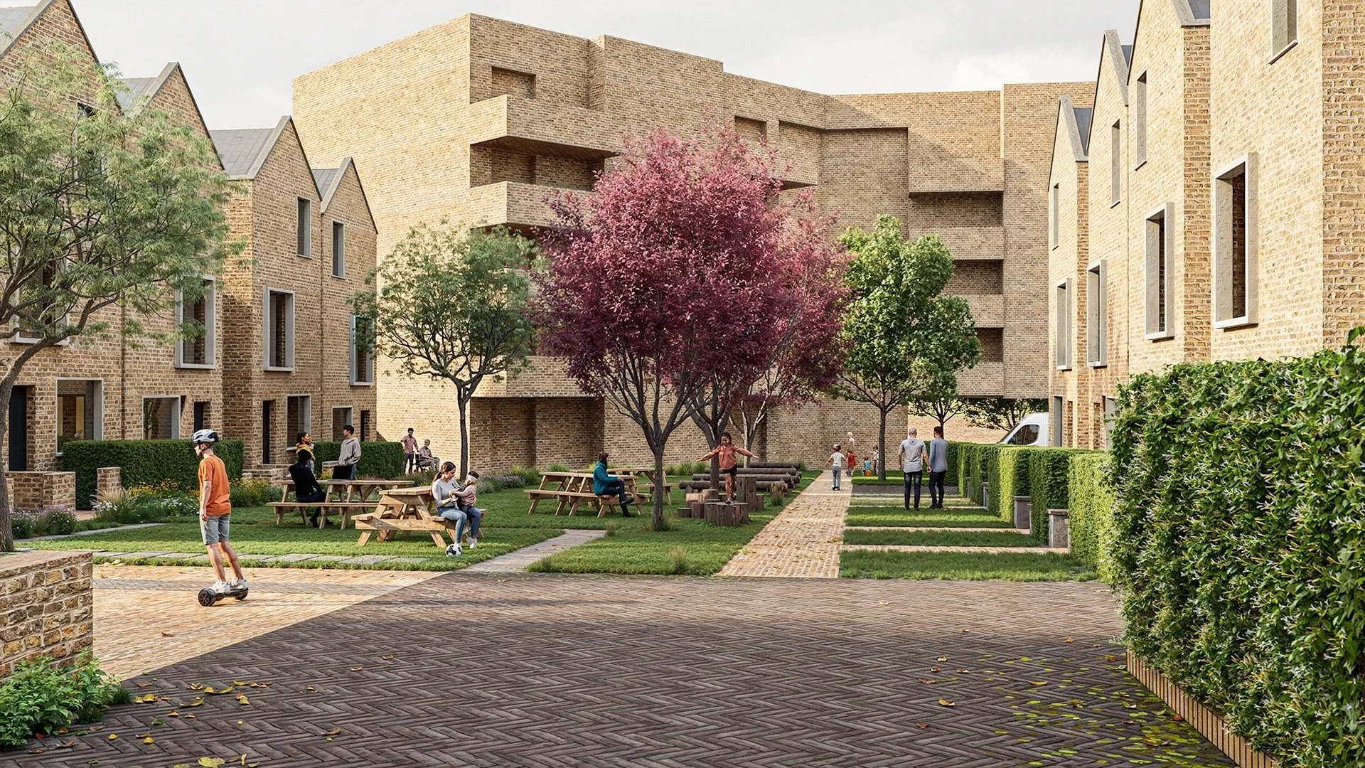 Residential courtyard visualisation showing modern brick buildings with pitched roofs, landscaped green spaces, trees with mixed foliage, paved walkways, and communal seating areas. People are socialising, walking, and using the space, creating a liv