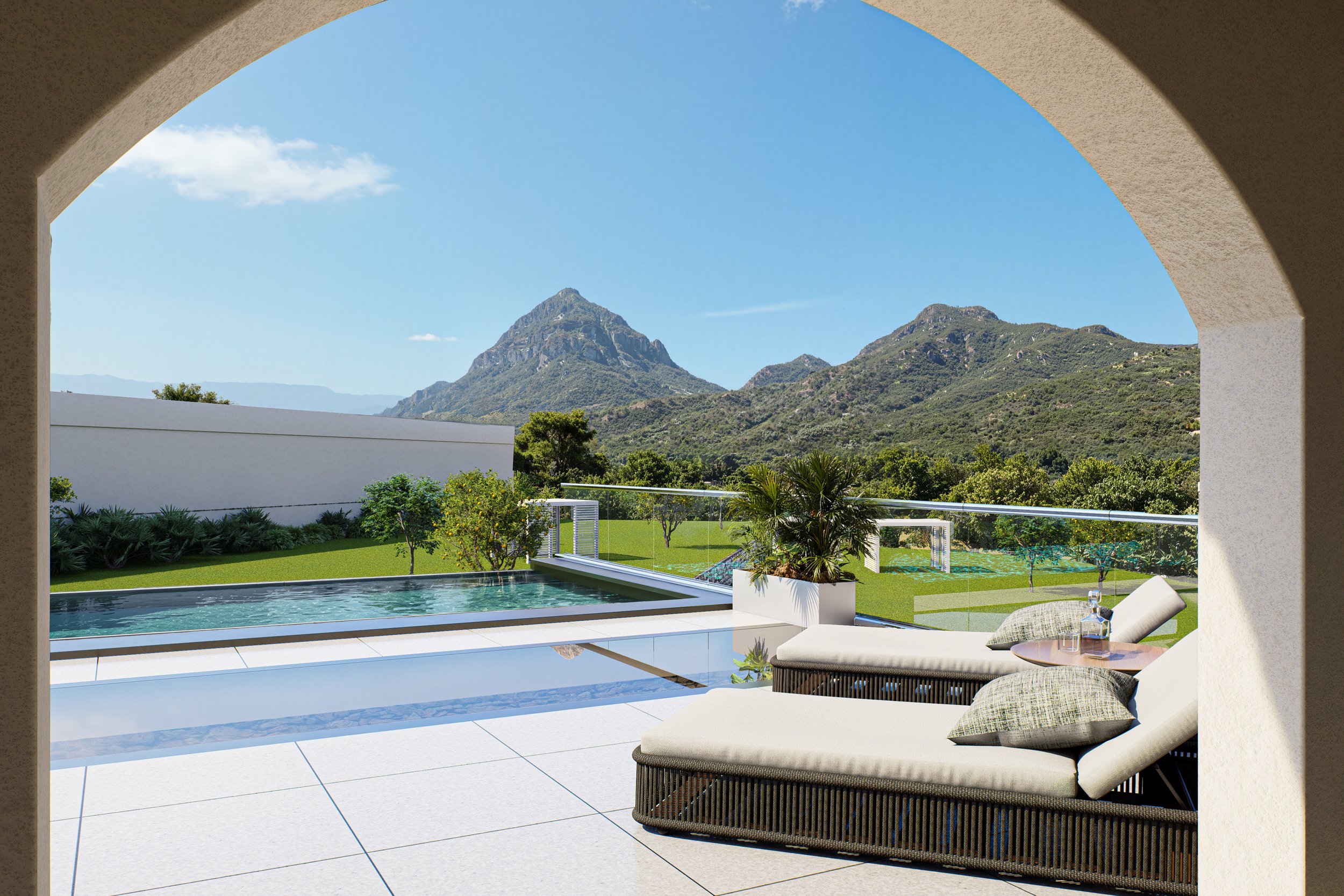 View of a backyard with a swimming pool, lounge chair with pillows, and a potted plant, overlooking green fields and mountain peaks under a clear blue sky.
