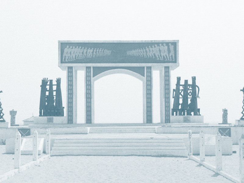 The image depicts a historical monument resembling the entrance to a city or event, with sculptures and an archway, set on a staircase with fencing.