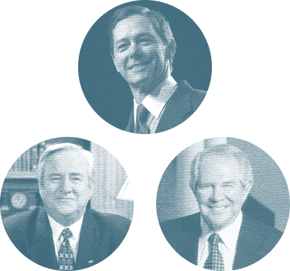 Portrait of three men in suits, smiling, with one man at the top and two men at the bottom, in a professional setting.