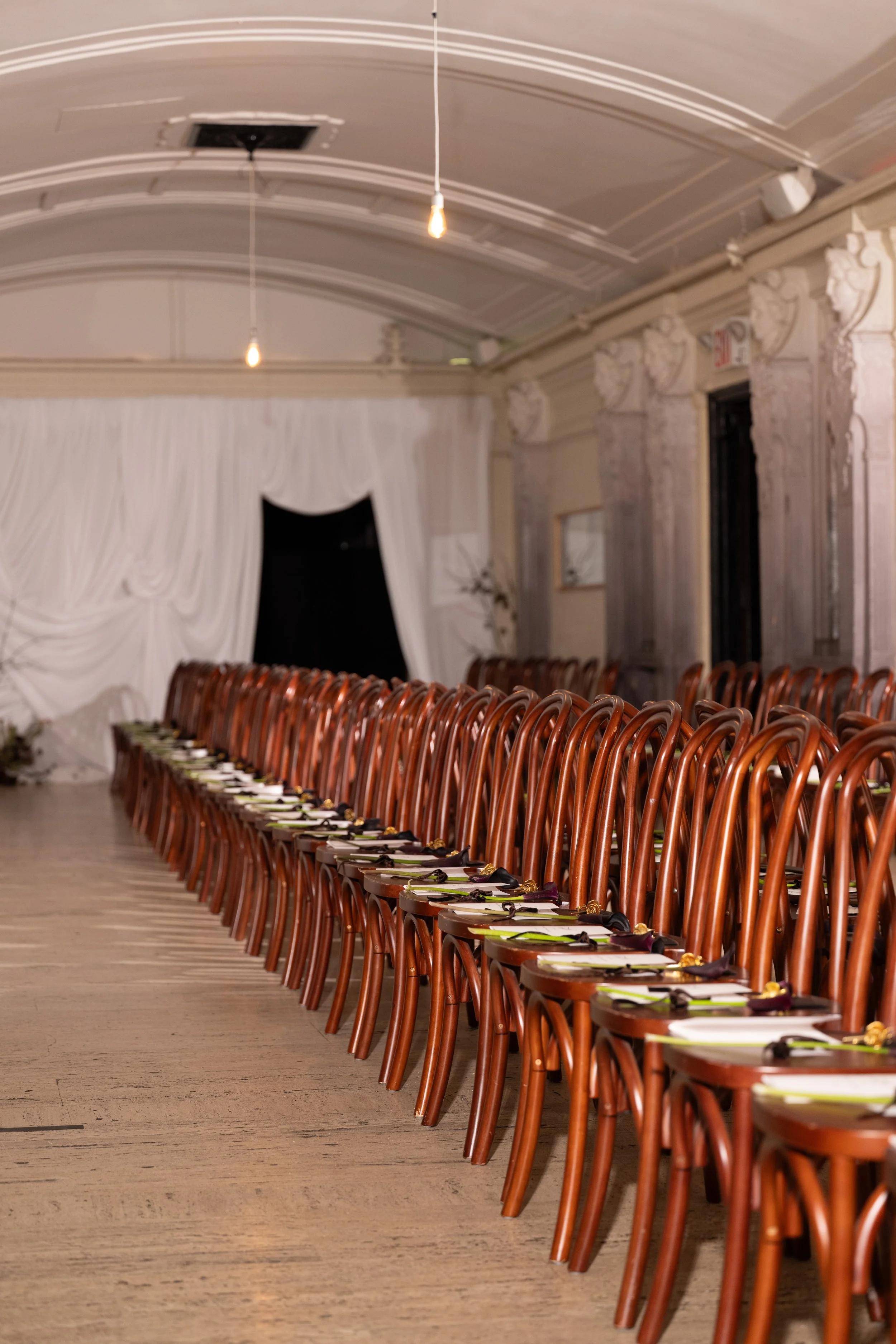 Salon-style runway seating, draped scenic installation and floral details for Tang Chi Couture’s NYFW SS27 show at Freehand New York.