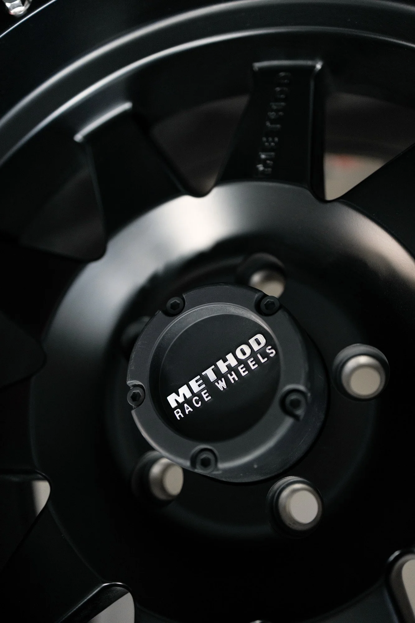 Close-up of black Method Race Wheels with silver lug nuts