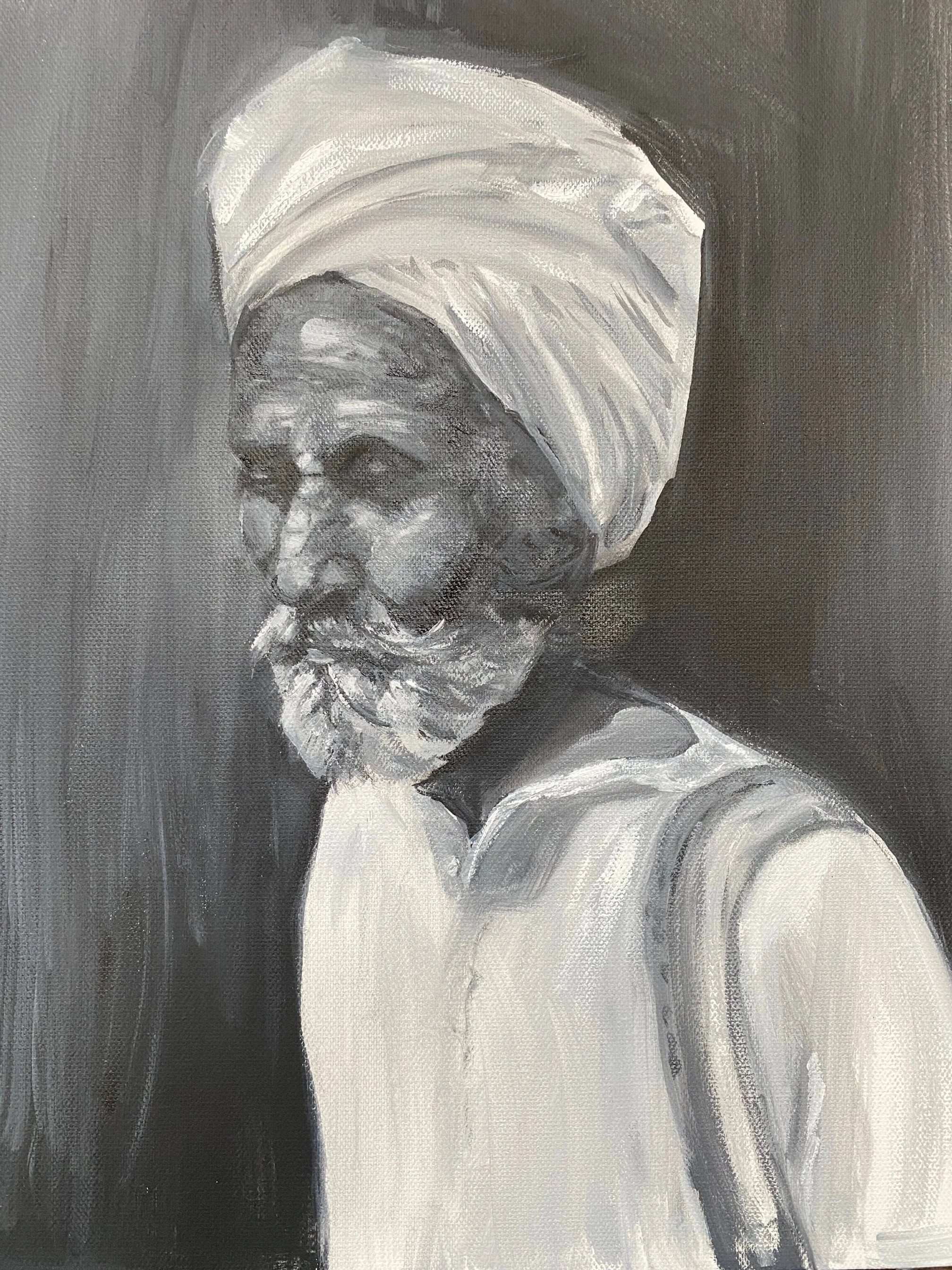 Black and white portrait of an elderly man wearing a turban and traditional clothing.