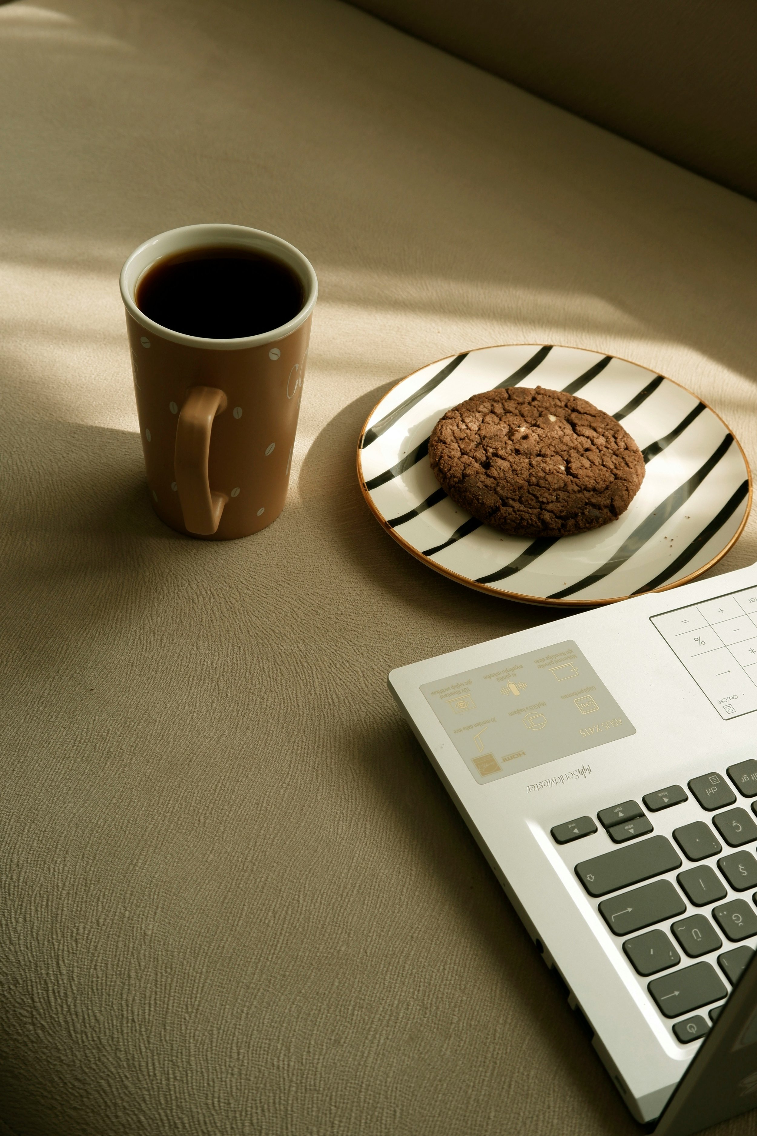 Coffee and laptop on a table, representing participation in an online mindfulness-based eating program