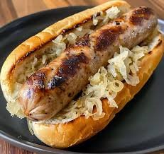 Hot dog in a bun topped with chopped onions.