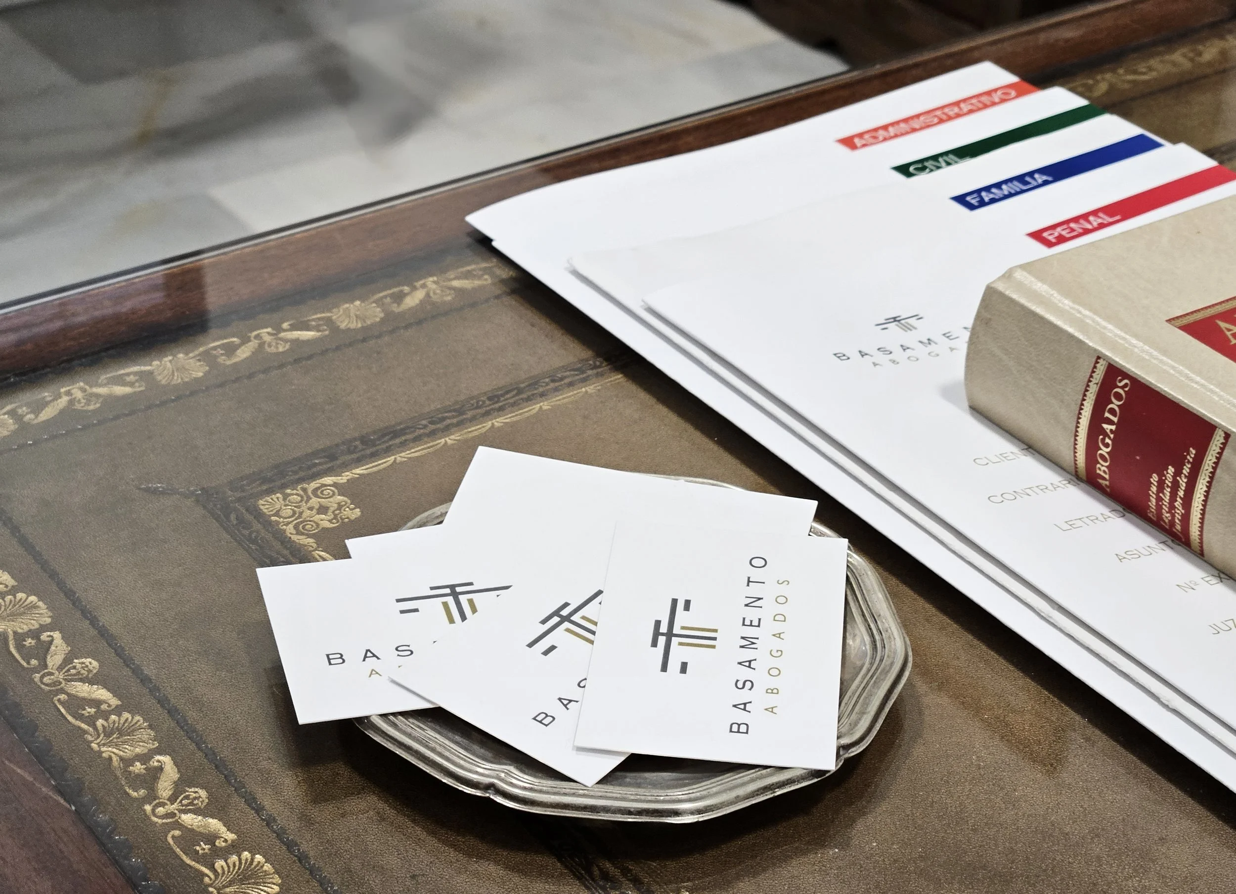 Tarjetas comerciales y papeles de abogados en una mesa de madera.