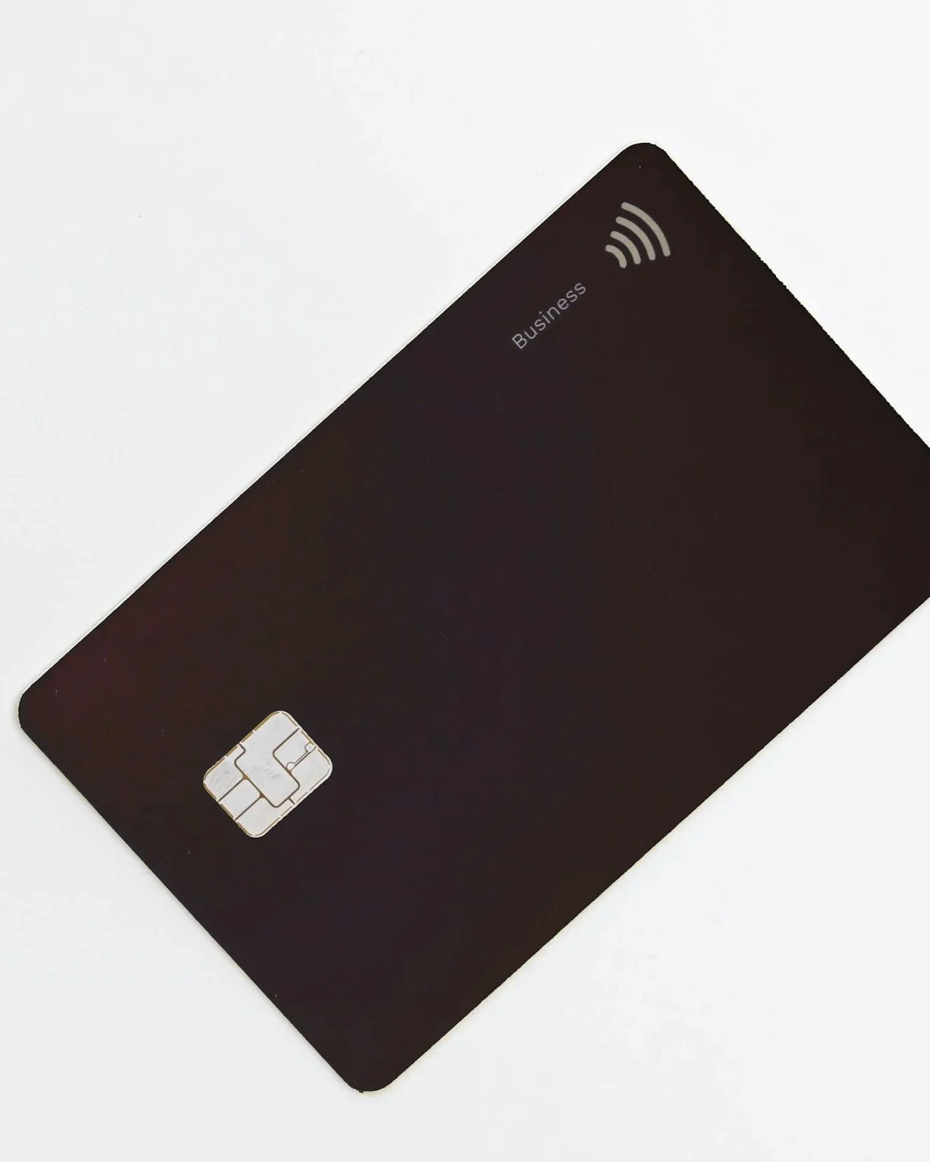 Tarjeta de crédito negra con etiqueta de negocio y símbolo de Wi-Fi en la esquina superior derecha, sobre fondo blanco.